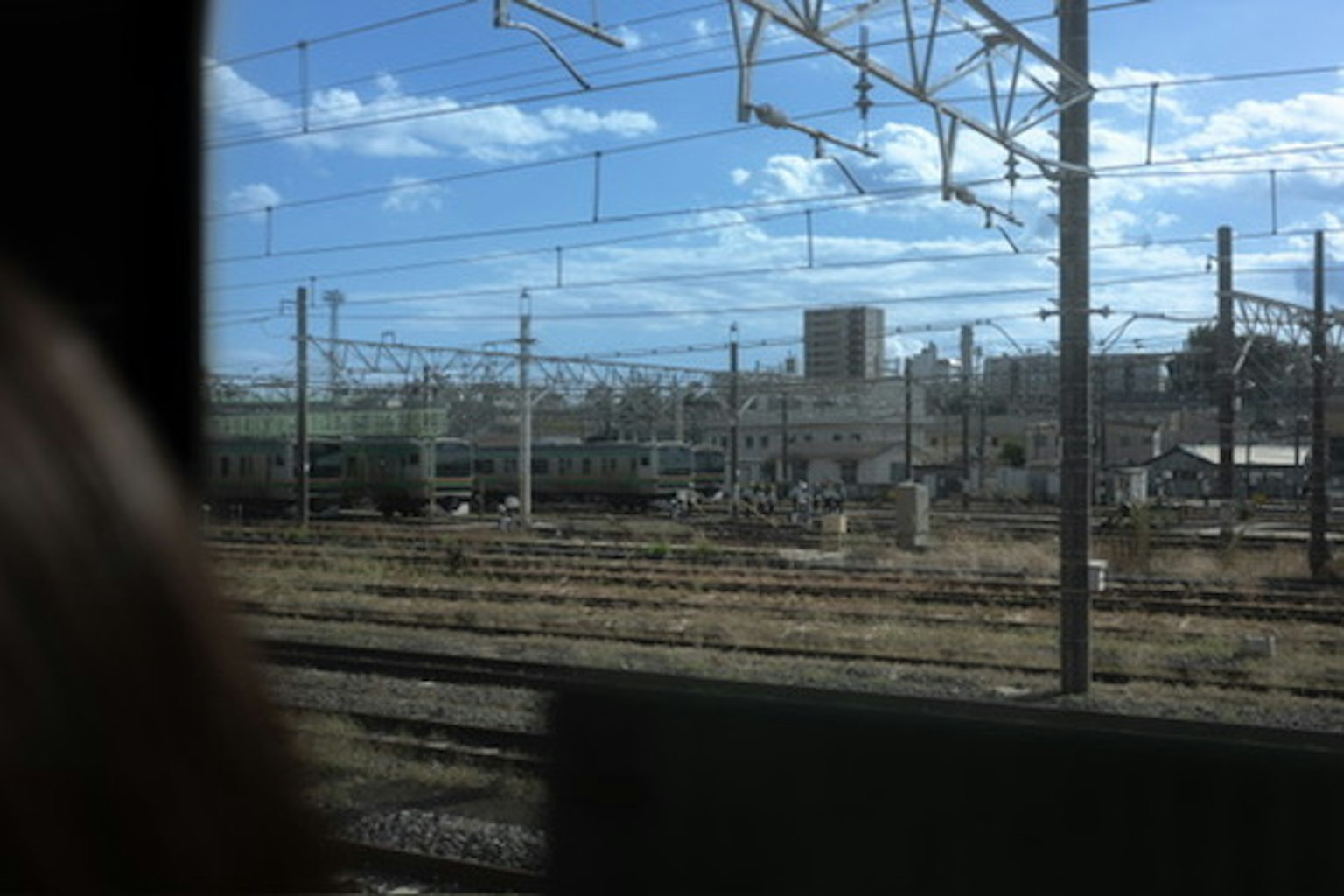 Blick auf die Bahngleise und den blauen Himmel aus einem Zugfenster