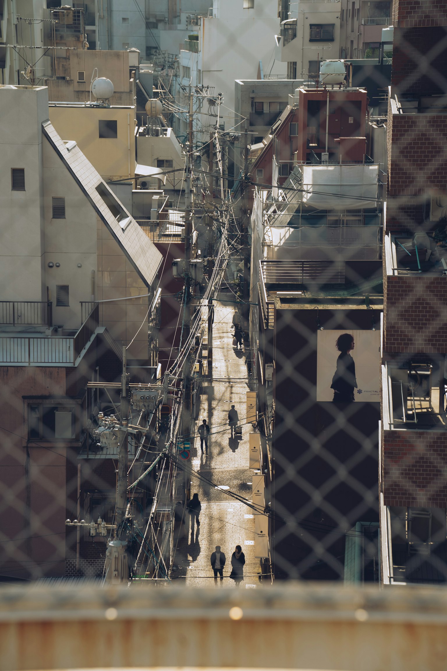 Scena urbana con persone che camminano lungo una stretta via fiancheggiata da edifici