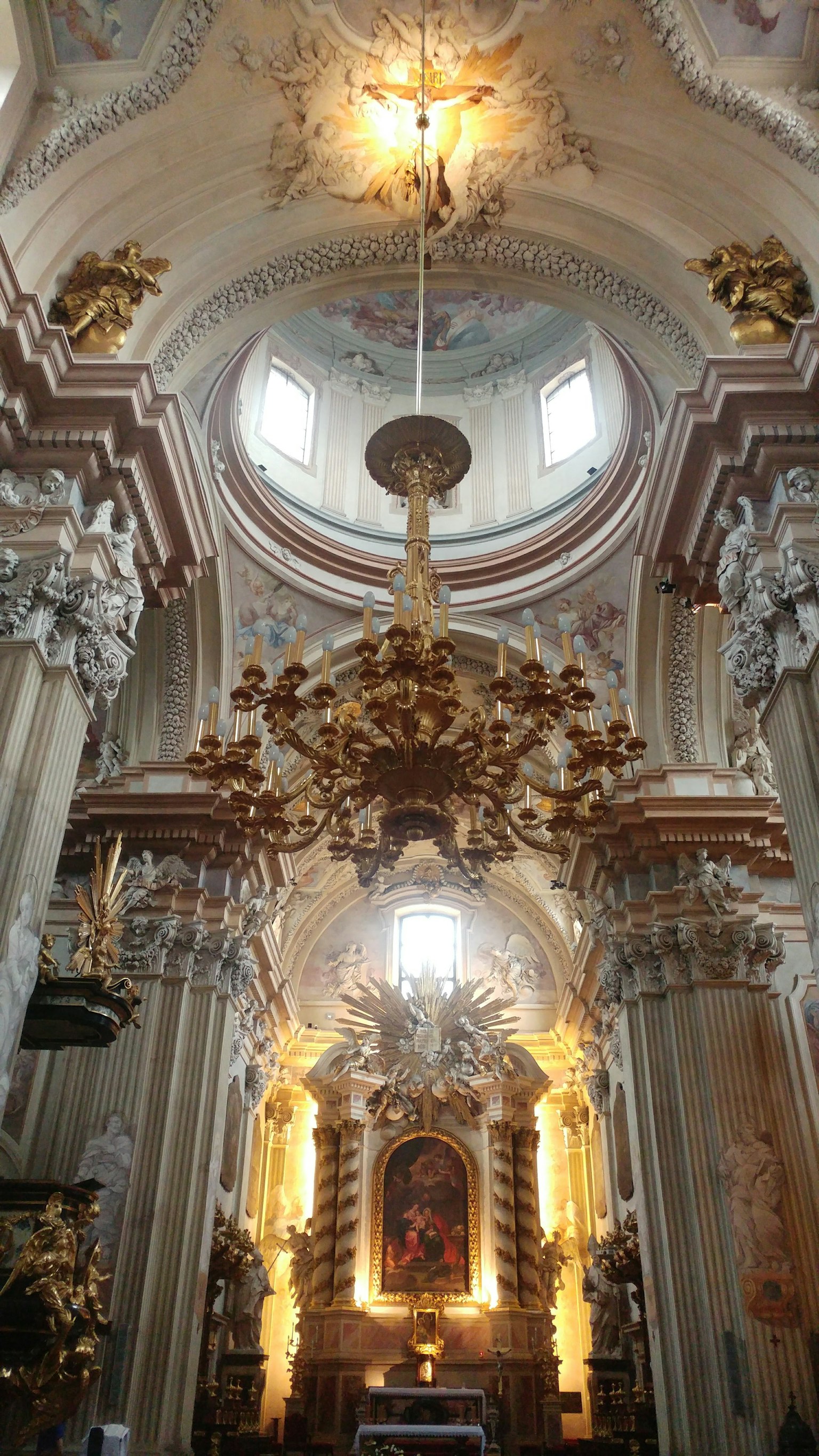 Wunderschönes barockes Kircheninnere mit einem verzierten Kronleuchter und dekorativen Skulpturen