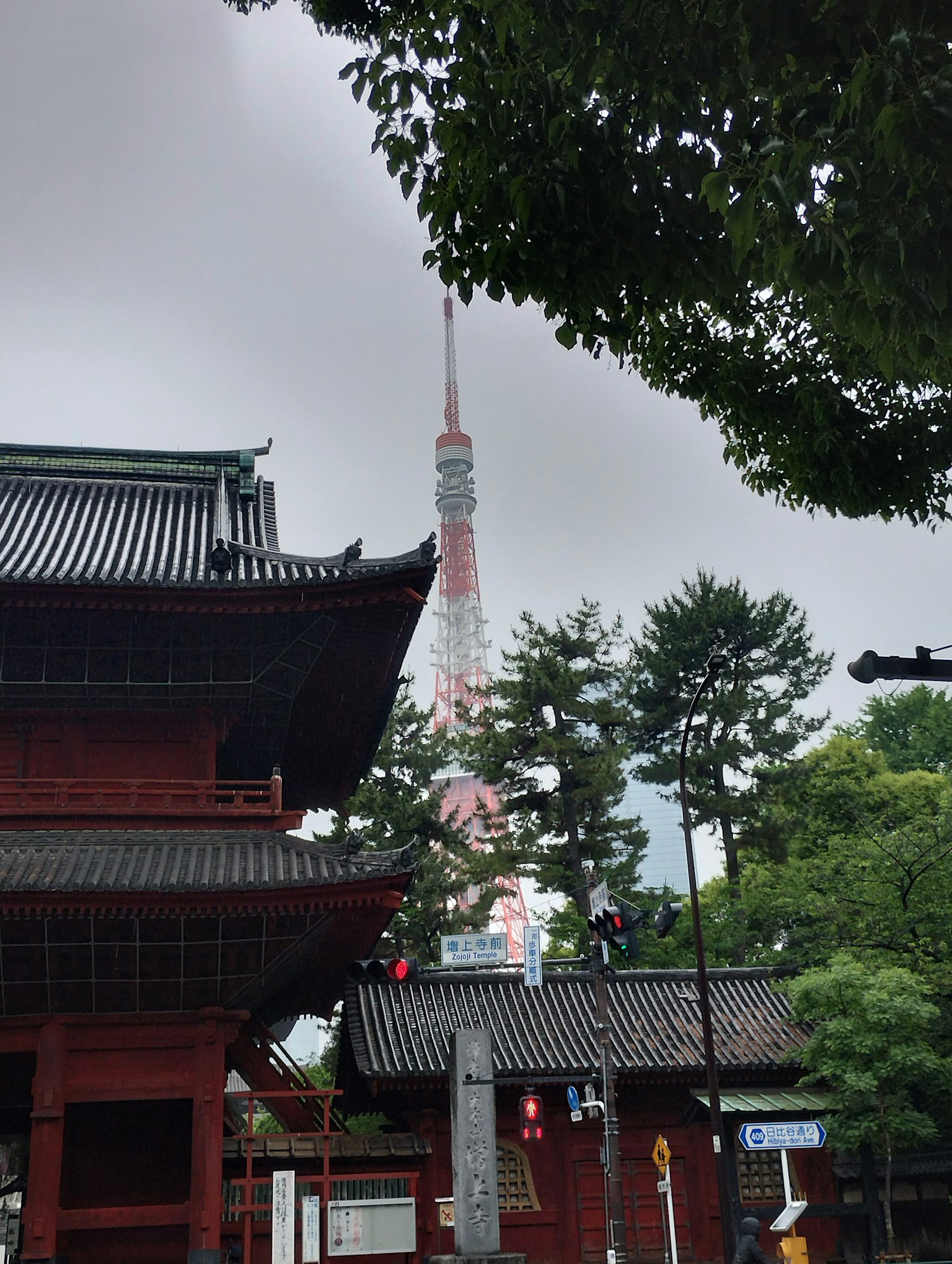 Traditional Japanese building with Tokyo Tower in the background and green trees