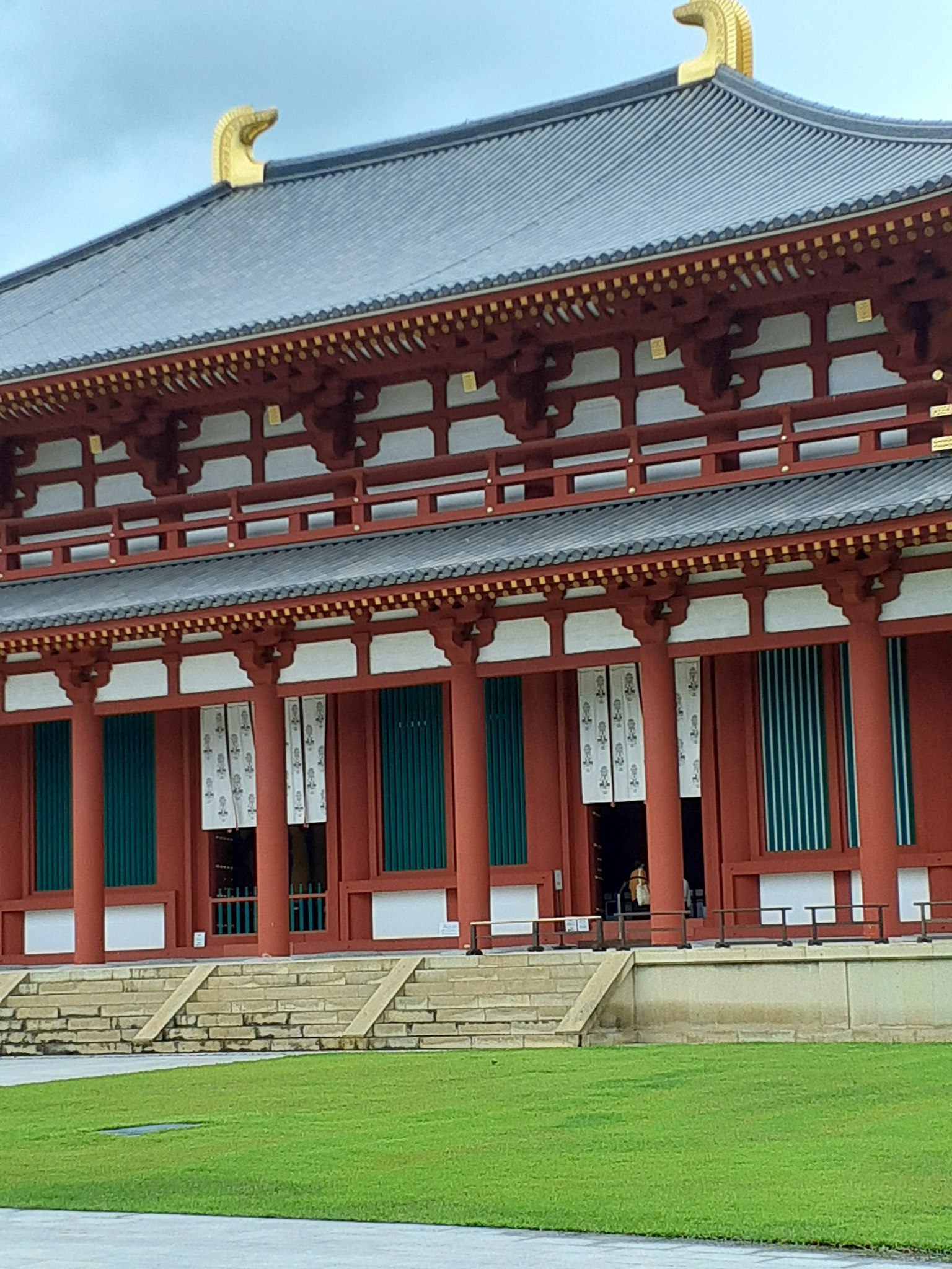 Arquitectura tradicional de un templo japonés con columnas rojas y césped verde