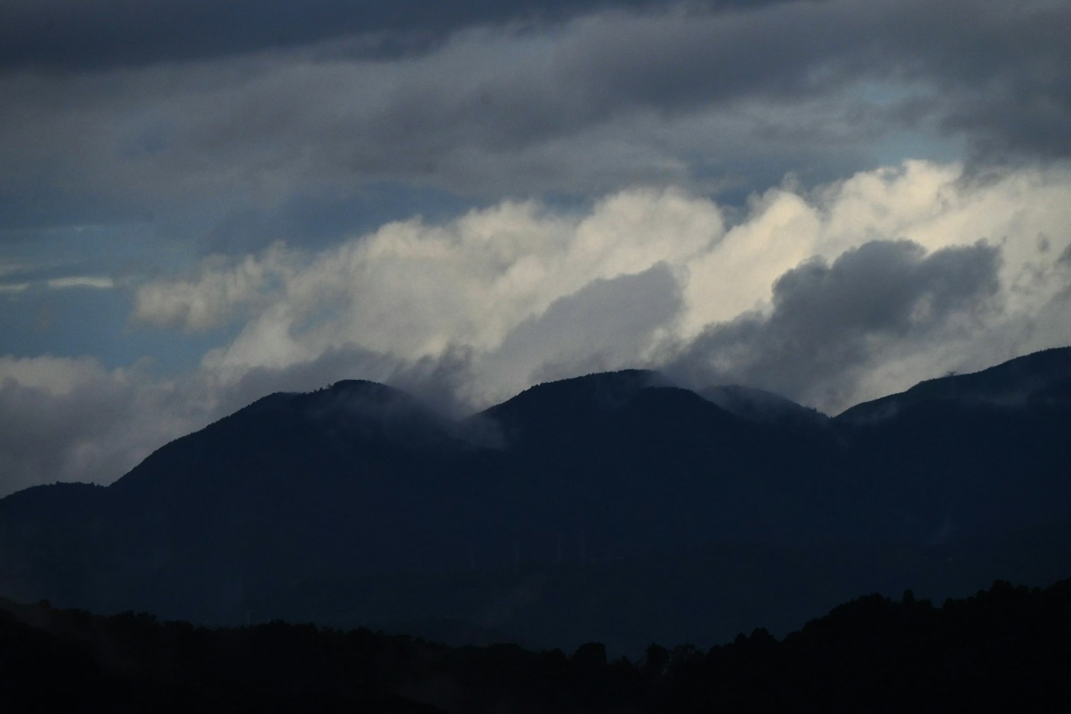 Silhouette von Bergen, die von dunklen Wolken umhüllt sind