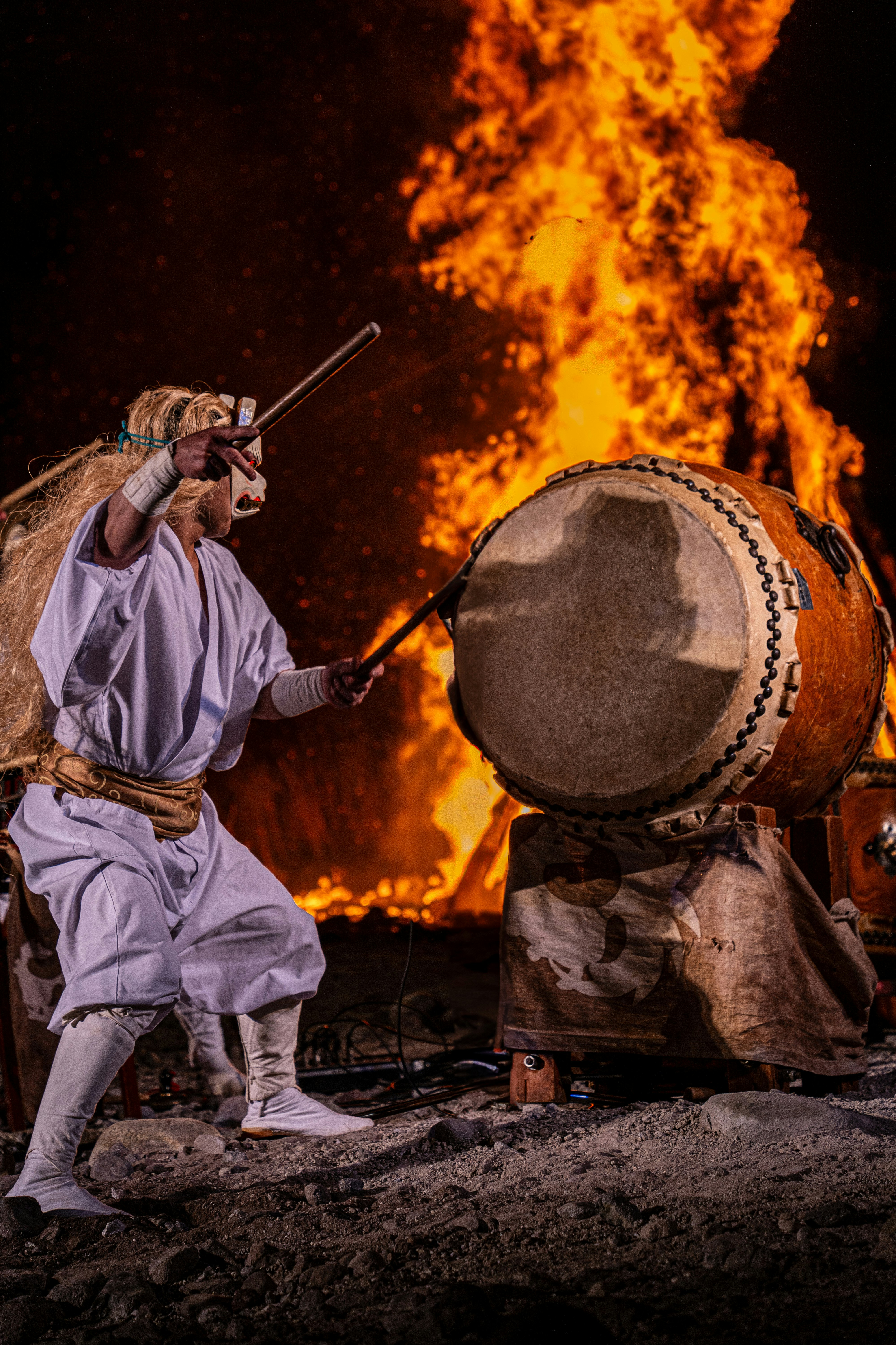 炎上する太鼓と火祭りの衣装をまとった祭りの人々