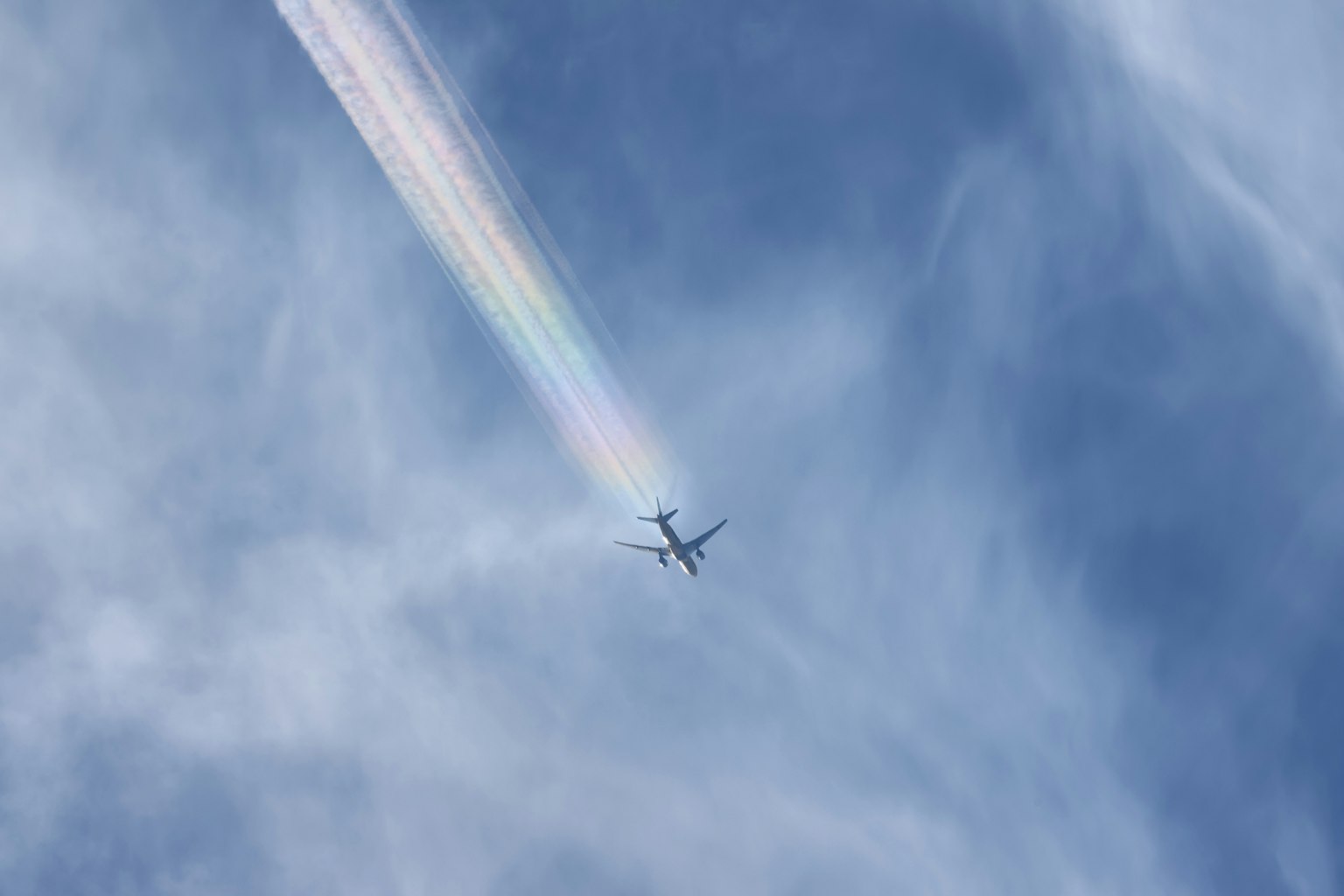 Avion volant dans un ciel bleu laissant une traînée colorée