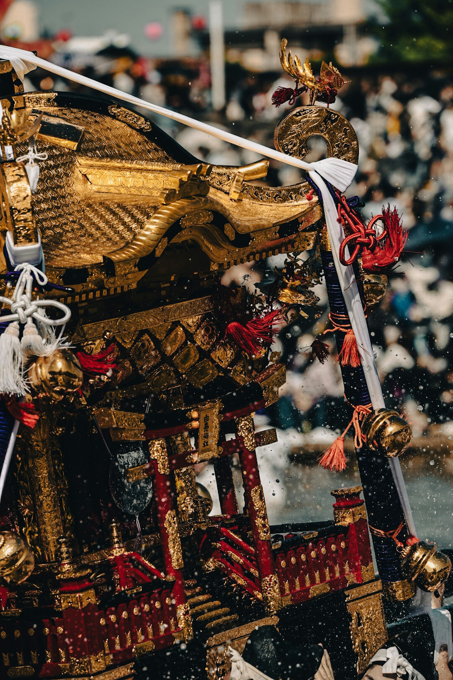 Mikoshi vàng đang lắc lư trong lễ hội với đám đông ở phía sau