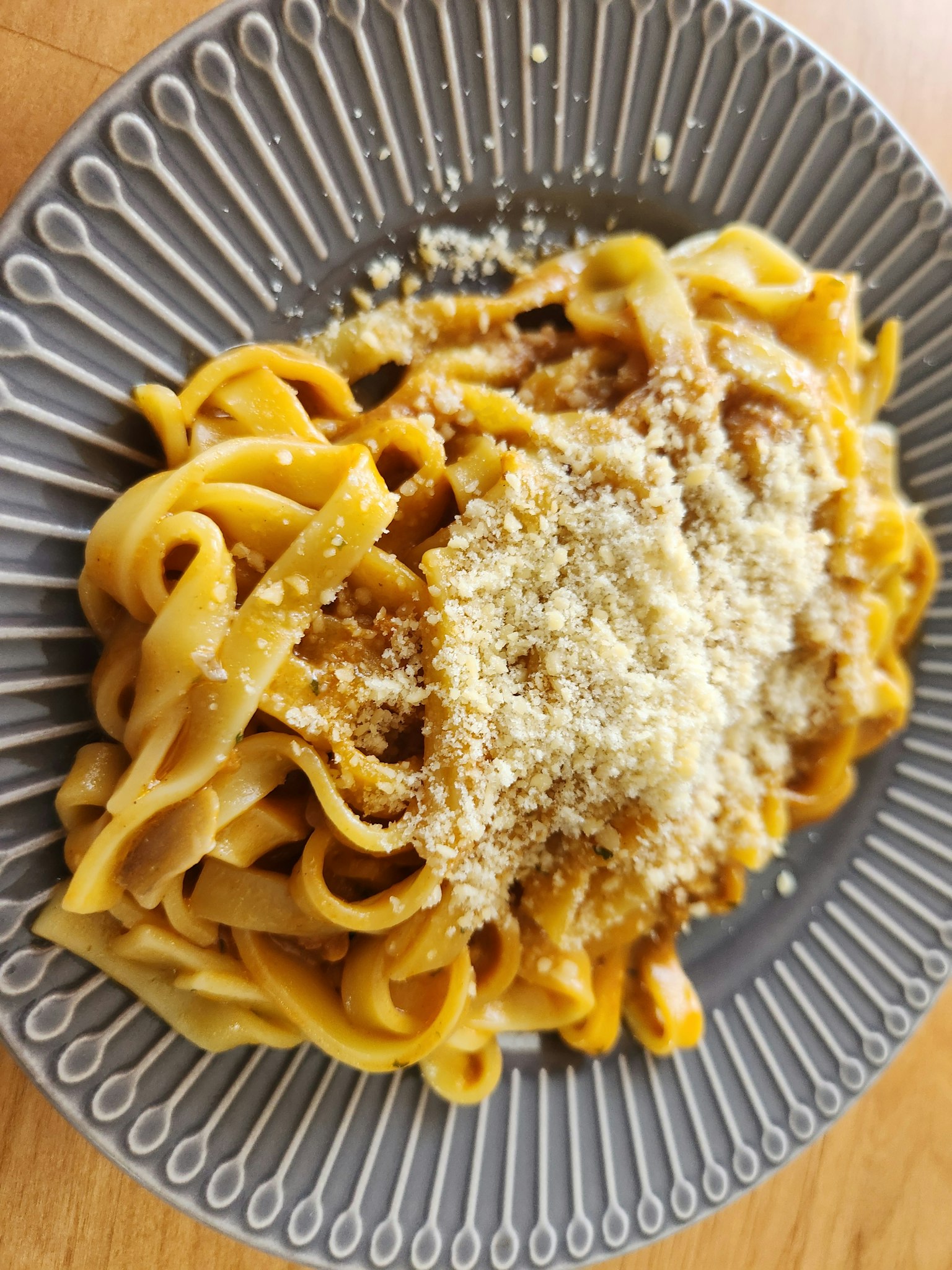 Teller mit Fettuccine, garniert mit geriebenem Parmesan