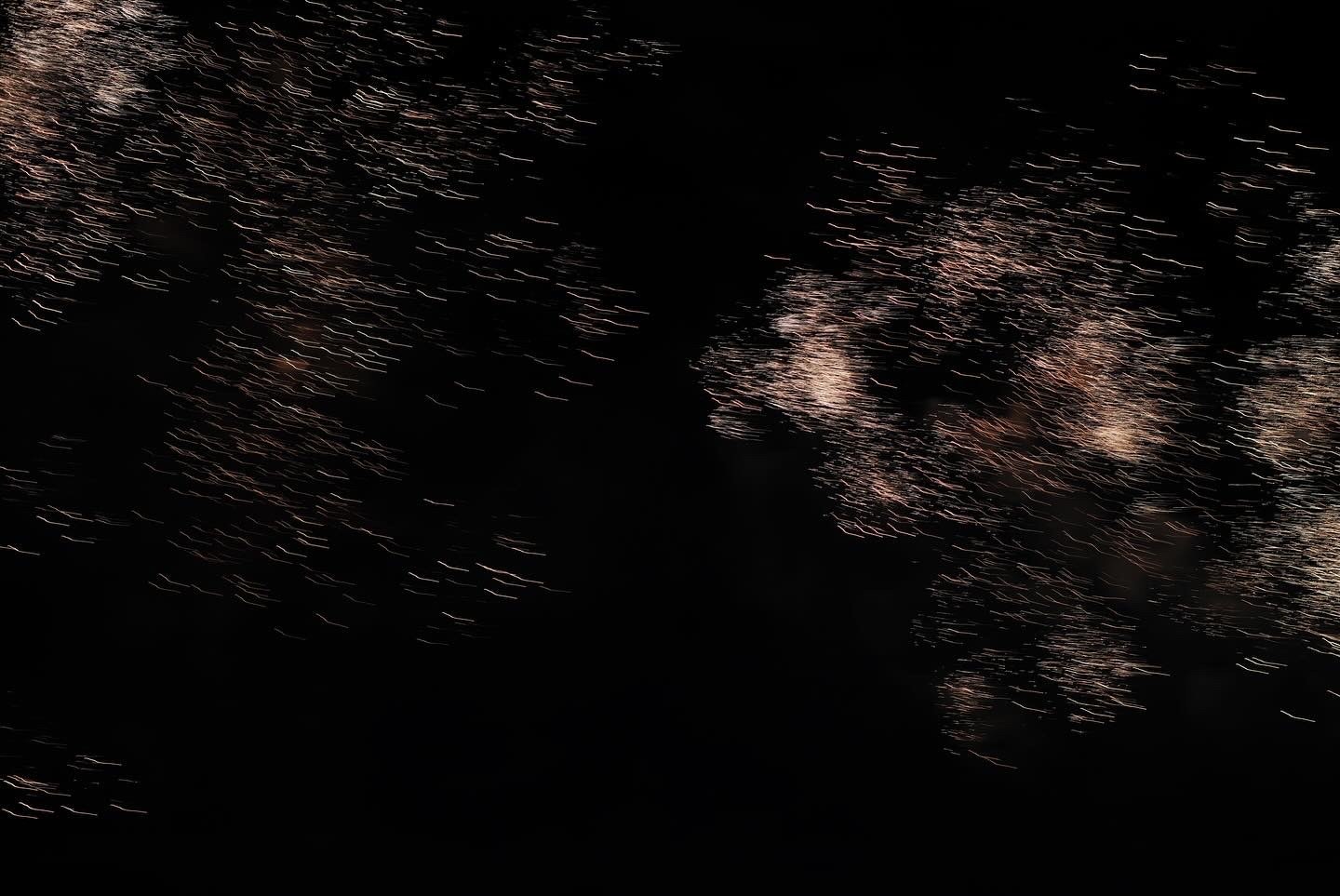 夜空に広がる花火の残光が水面ににじむ
