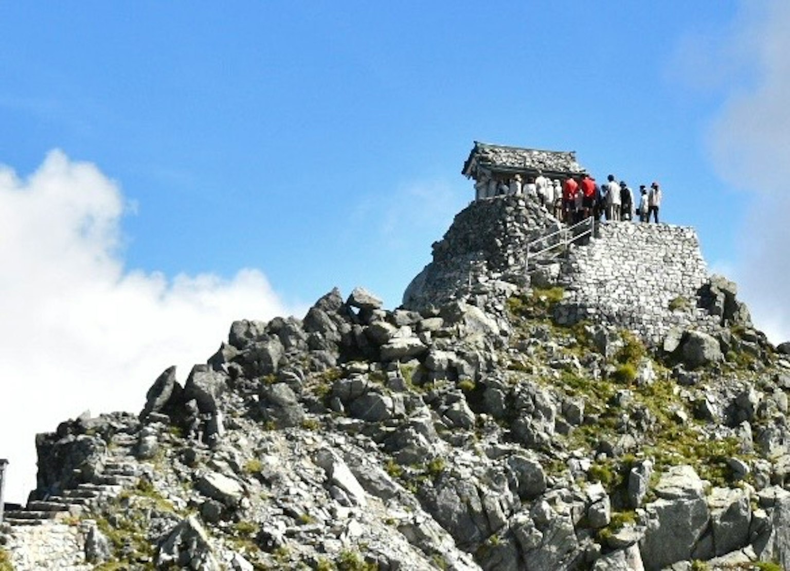 Một túp lều nhỏ trên đỉnh núi với một nhóm du khách