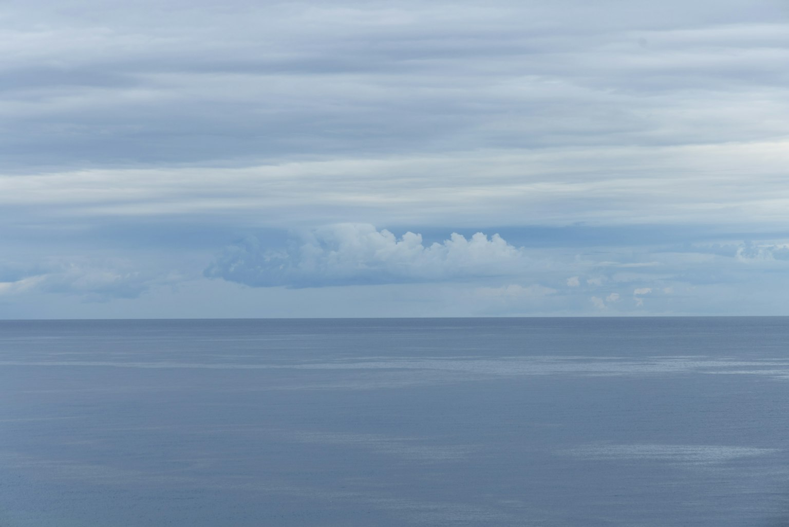 Calm seascape with blue water and clouds