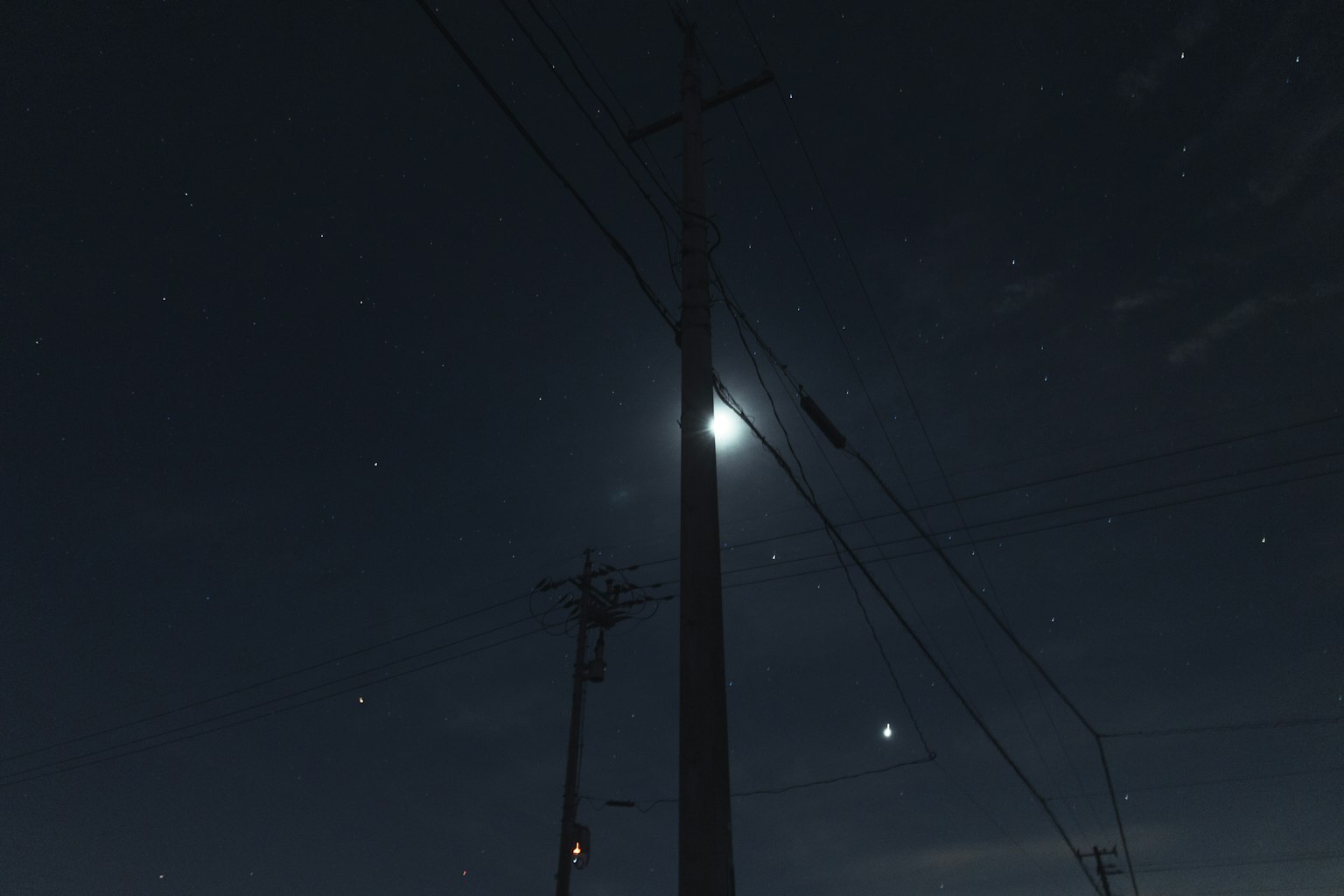 在星空背景下被月光照亮的电线杆
