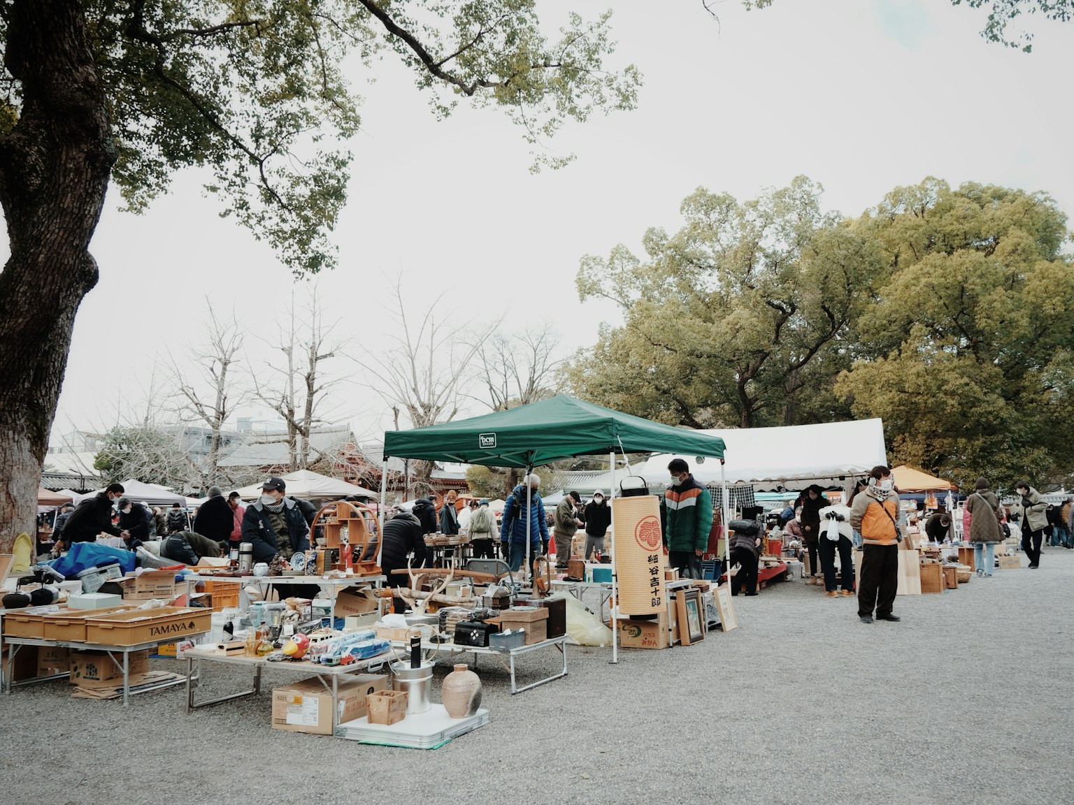 热闹的市场场景，有人和各种物品在桌子上