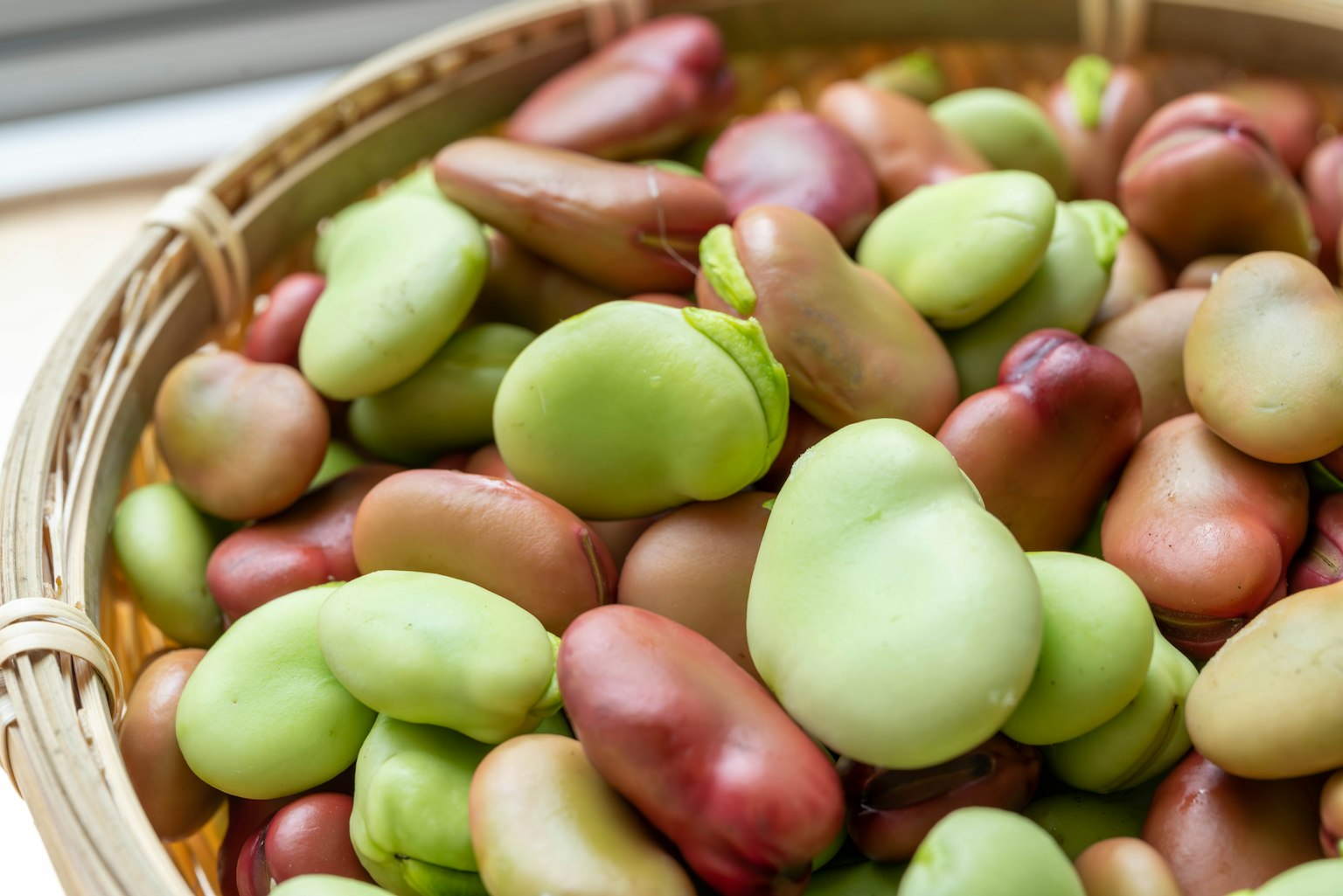 Gros plan de divers haricots colorés dans un panier tressé