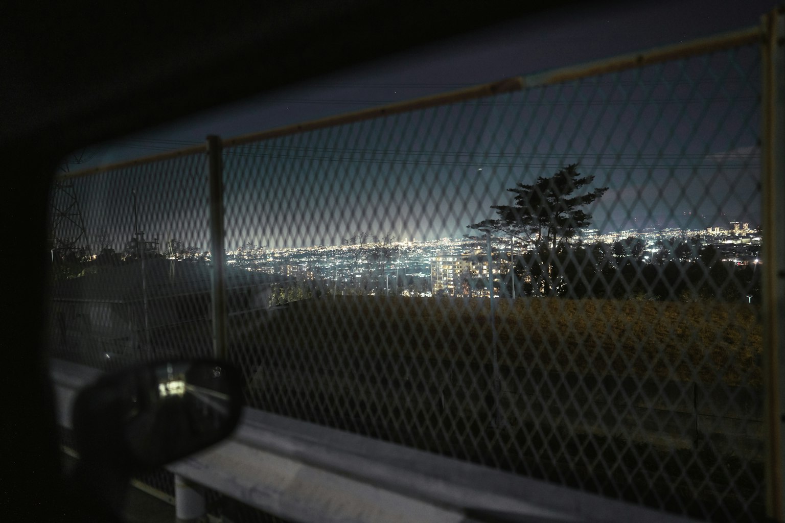 夜景とフェンス越しの都市の眺め