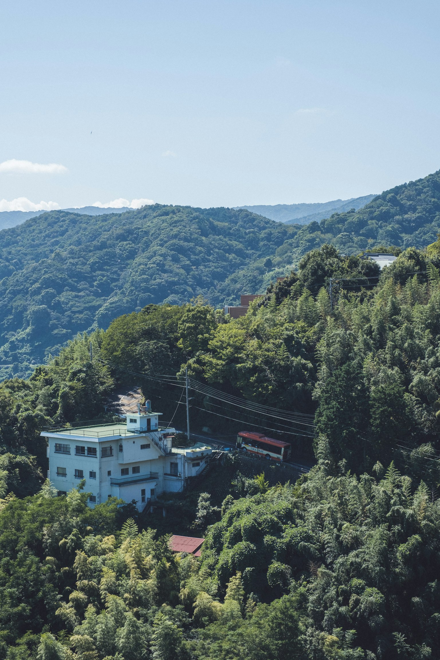 一栋蓝色建筑坐落在绿色山脉的风景中