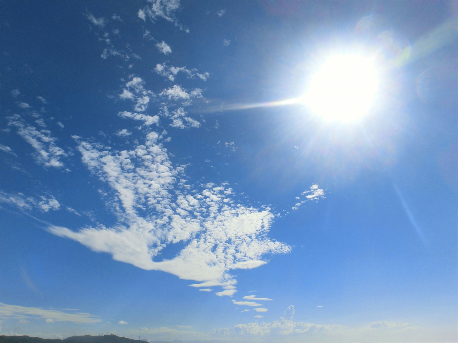 Soleil éclatant sur un ciel bleu clair avec des nuages épars