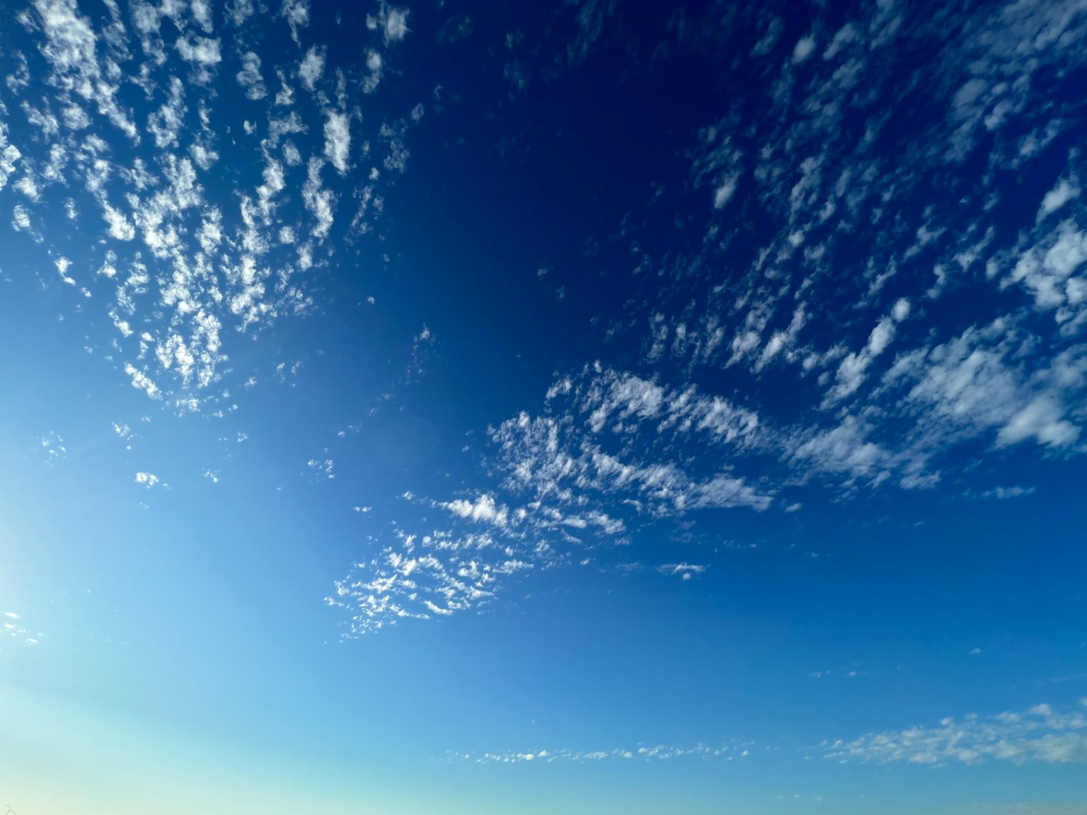Weitläufiger blauer Himmel mit verstreuten weißen Wolken