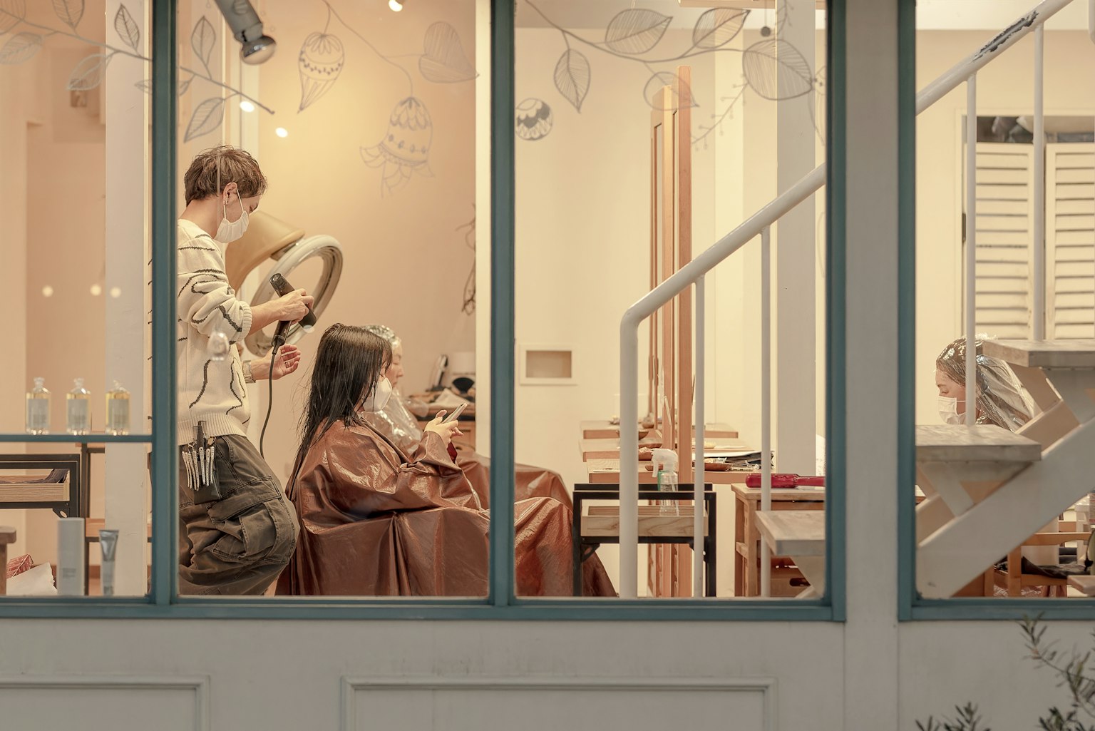 Une scène de salon de coiffure avec un styliste travaillant sur les cheveux d'une femme
