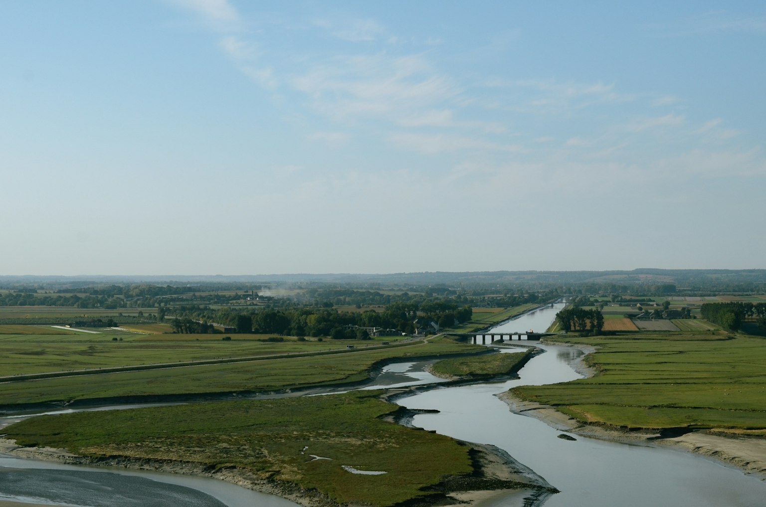 広がる緑の草原と川の風景青い空と雲が広がる