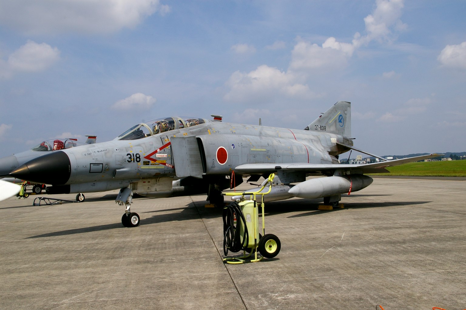เครื่องบินรบ F-4 Phantom II จอดอยู่บนรันเวย์ใต้ท้องฟ้าสีฟ้า