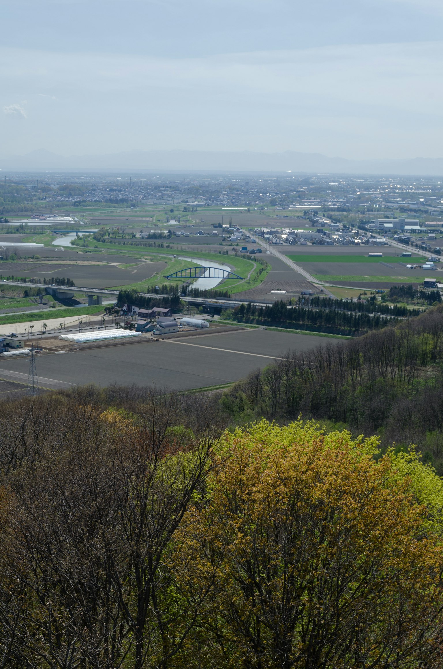 Vista escénica desde una colina verde que mira campos y tierras agrícolas