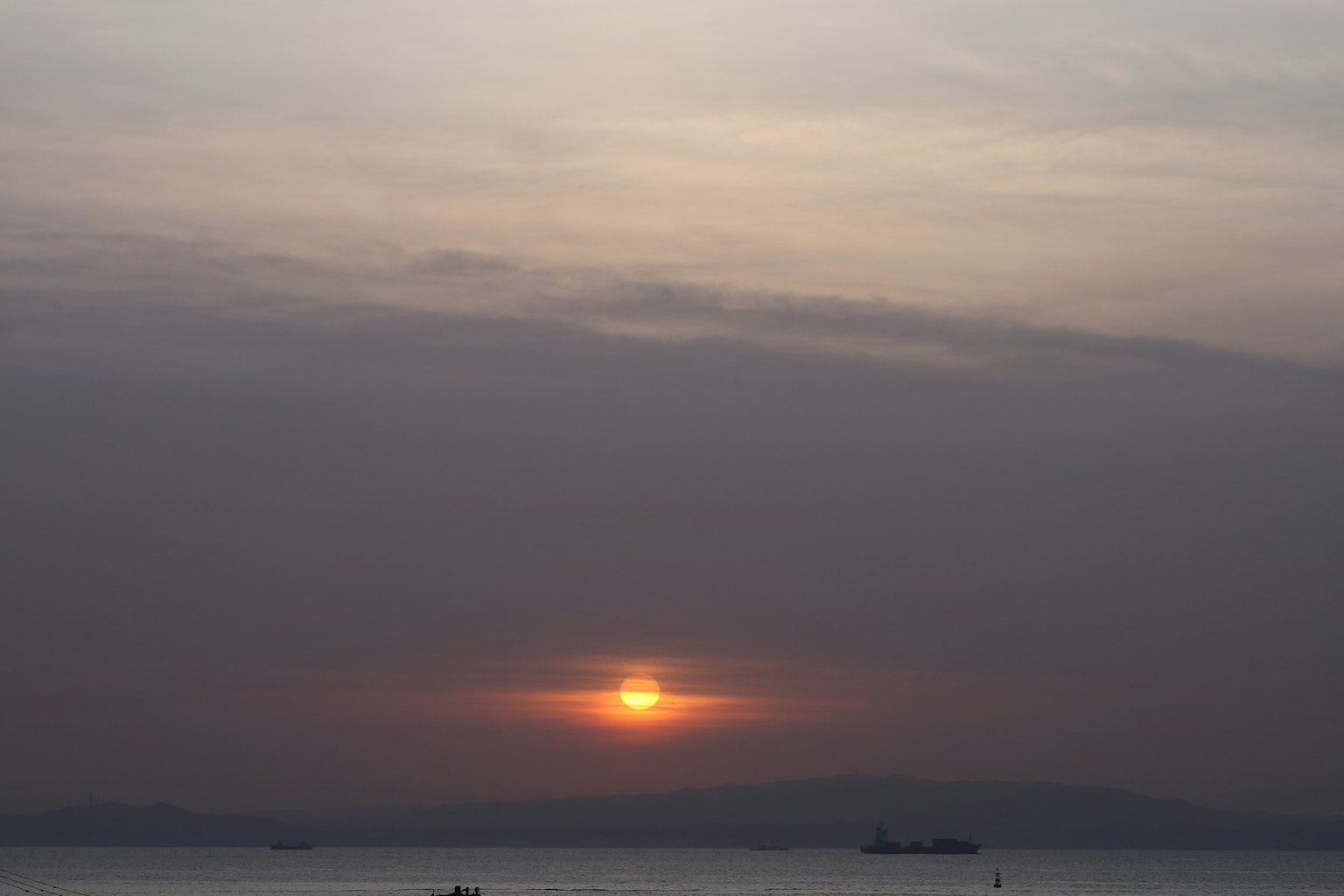 Tramonto sull'oceano con nuvole leggere