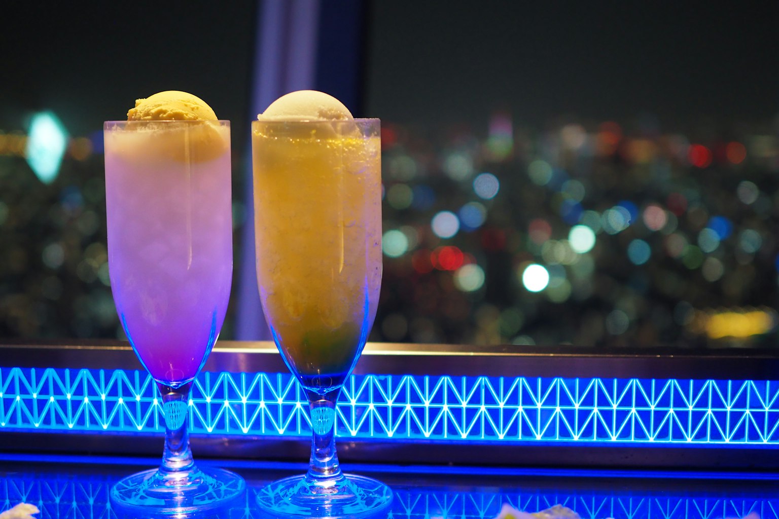 Cocktail colorati con gelato contro uno skyline notturno
