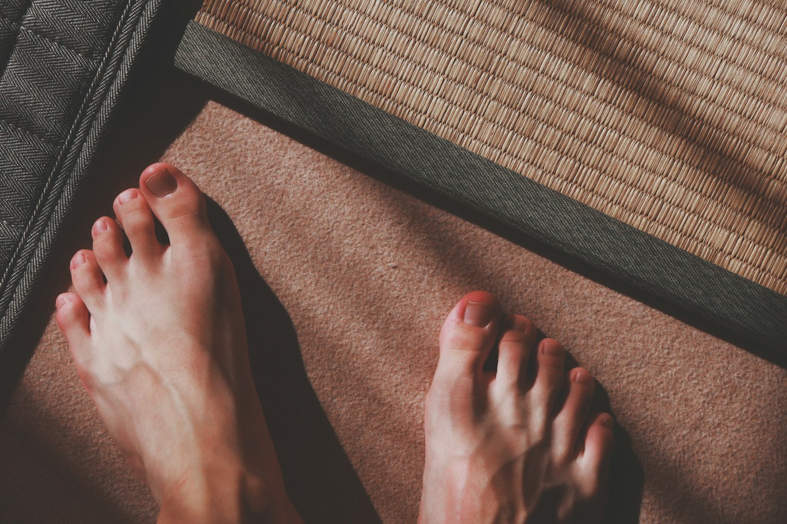 Bare feet on a mat and tatami flooring
