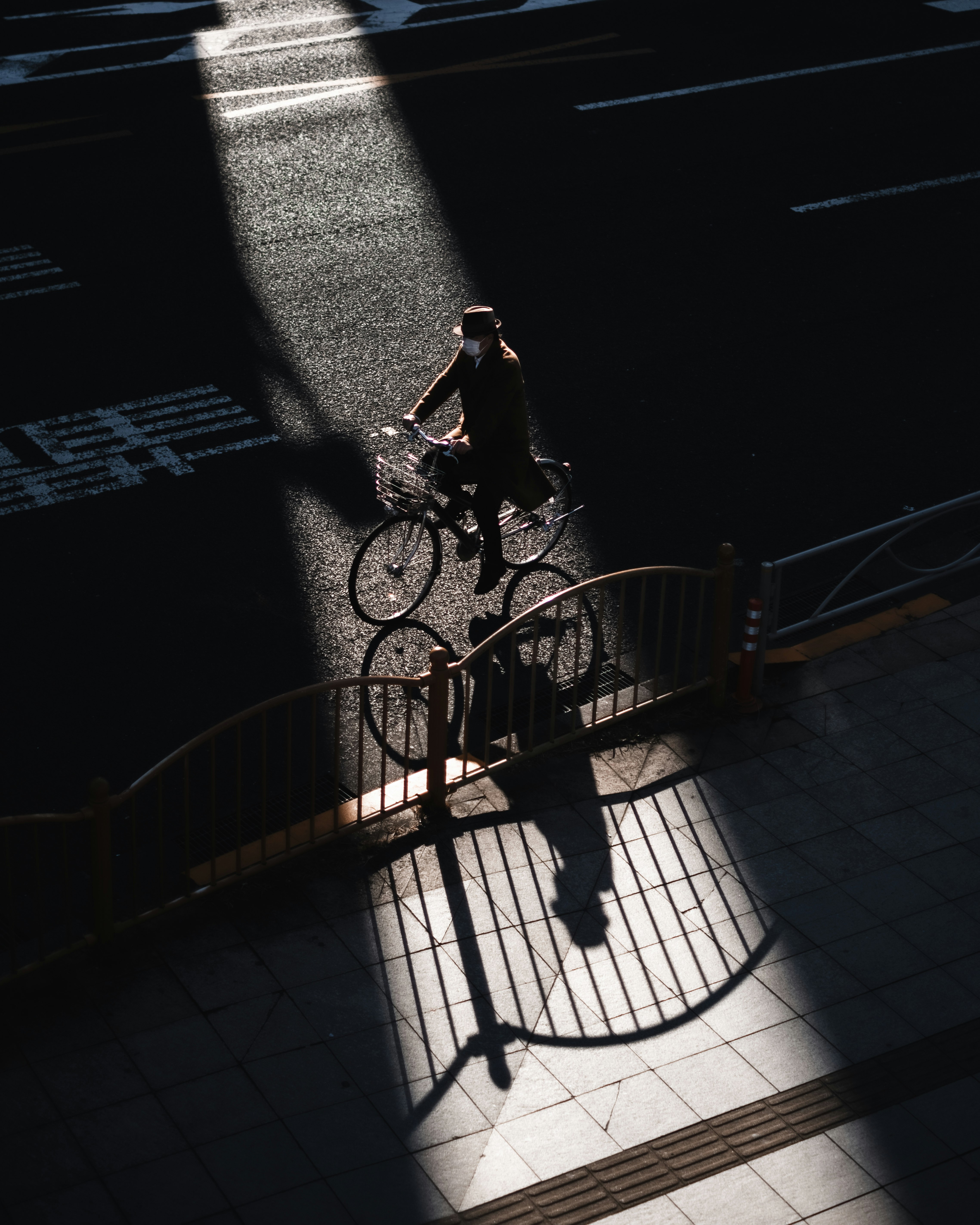 Una persona en bicicleta cruza un paso con escalones en una escena urbana al atardecer
