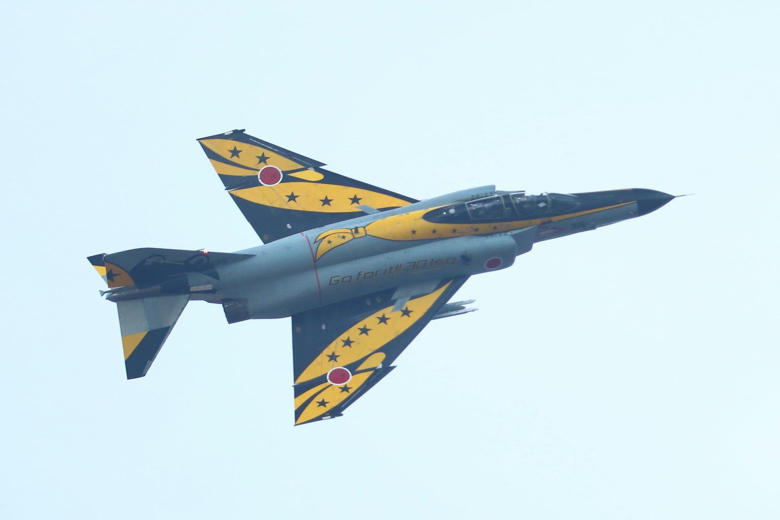 Avion de chasse coloré en vol avec un design jaune et noir