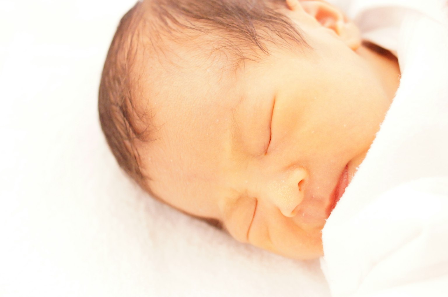 Un bambino che dorme su una coperta bianca
