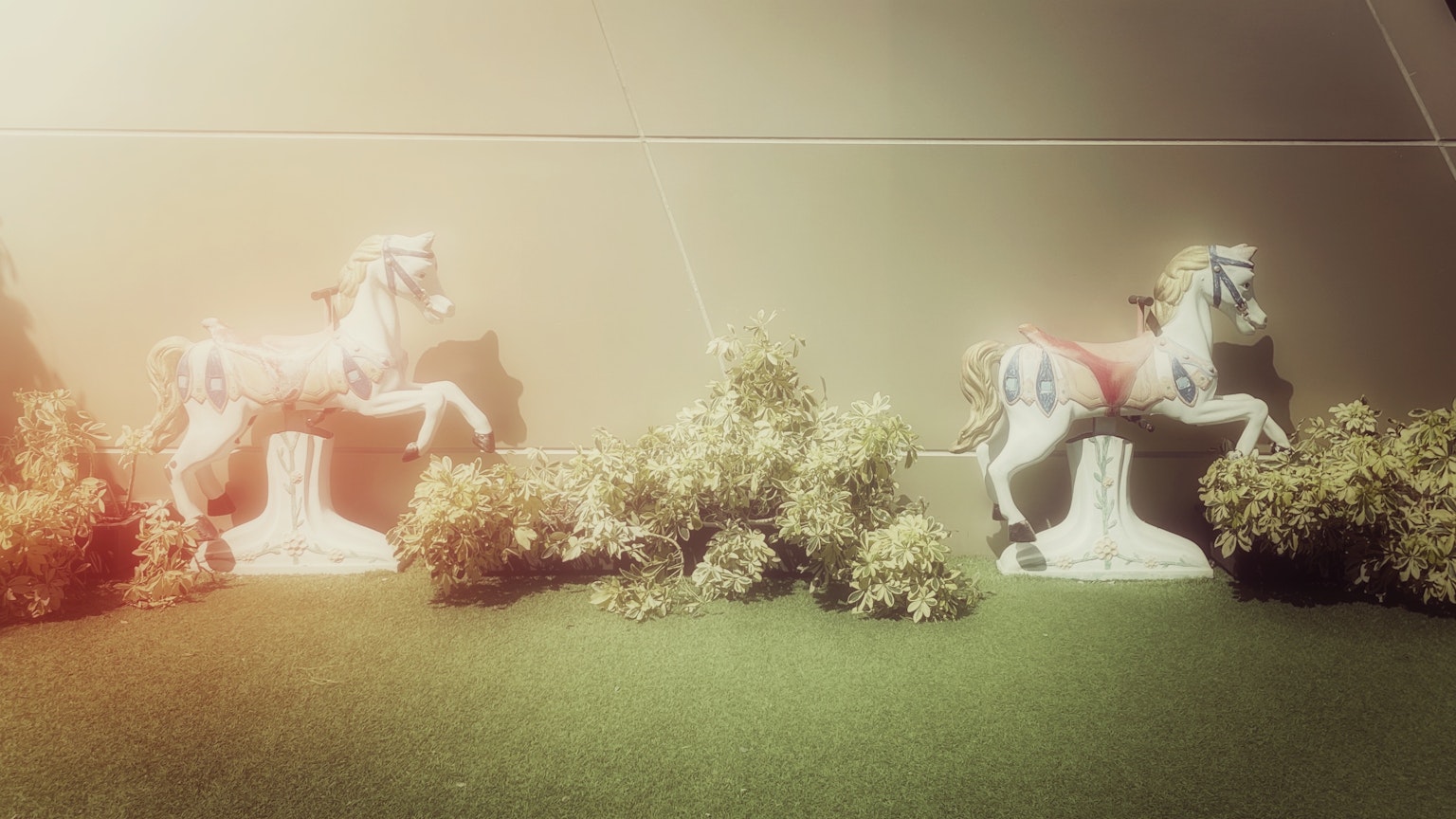白い馬の彫刻が緑の芝生の上に置かれた風景