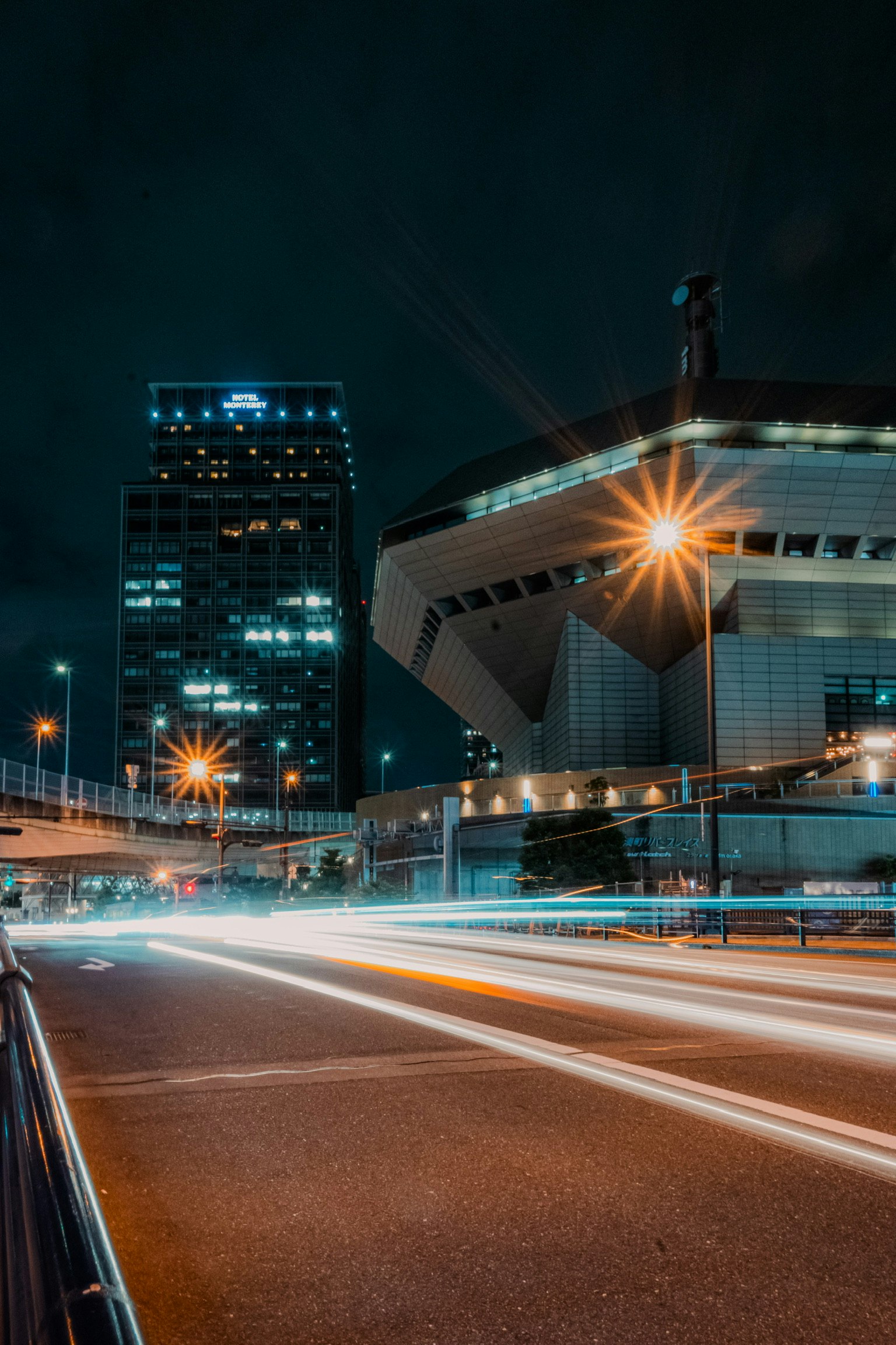 Night cityscape featuring skyscrapers and light trails from traffic