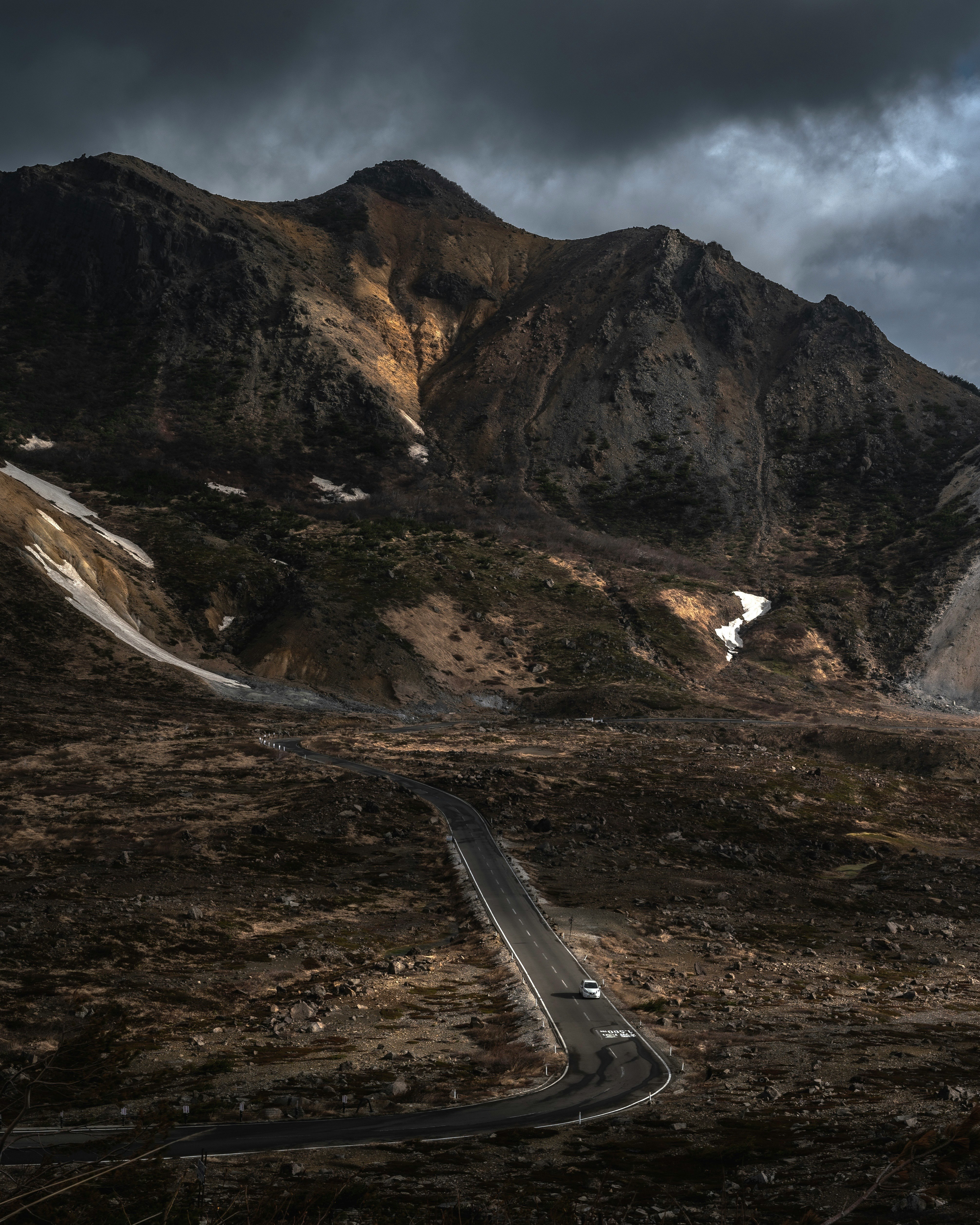 pentes montagneuses rocheuses avec une route sinueuse dans une vallée dramatique