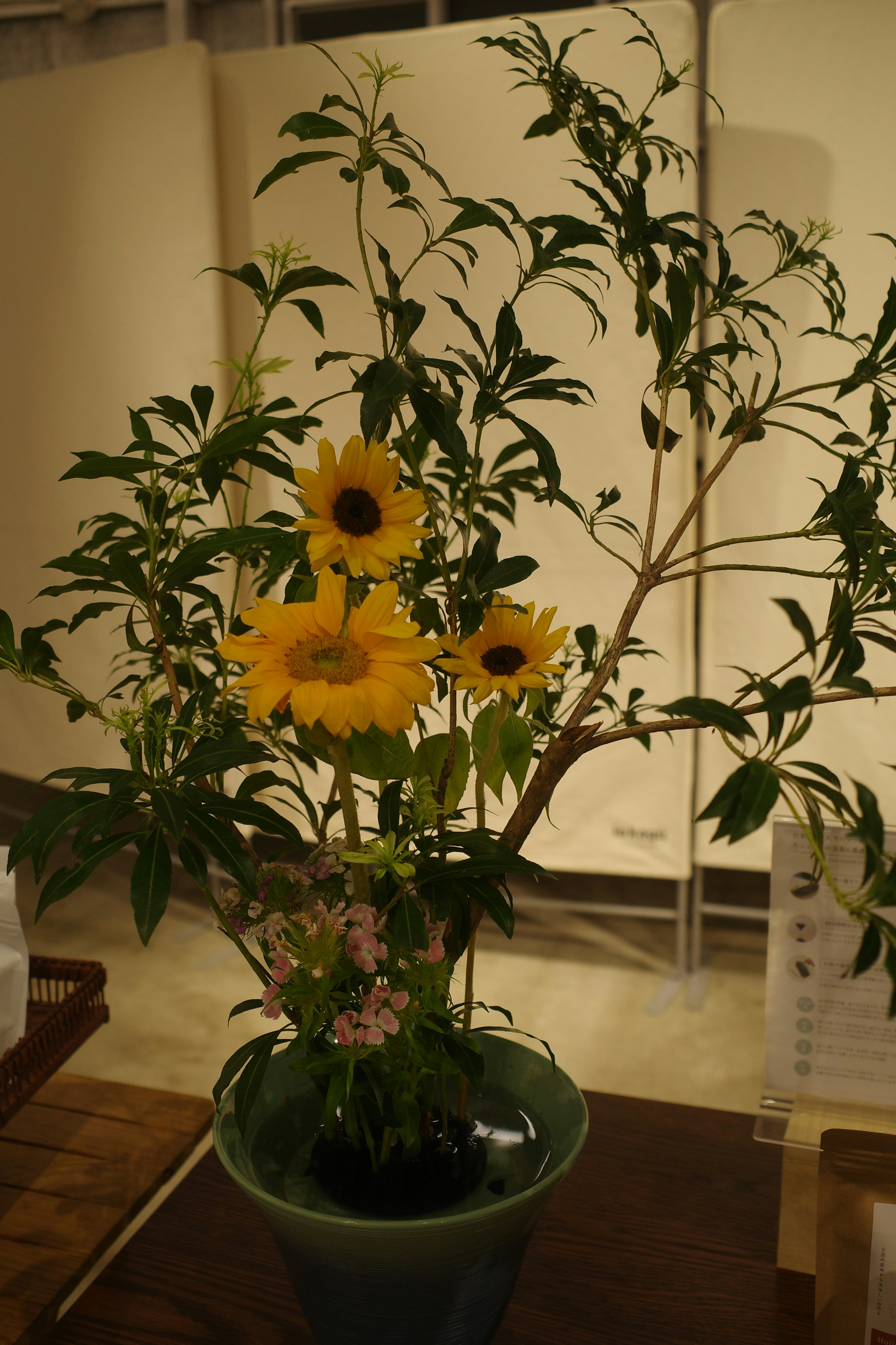 花瓶に生けられたひまわりと小花のある室内の花飾り