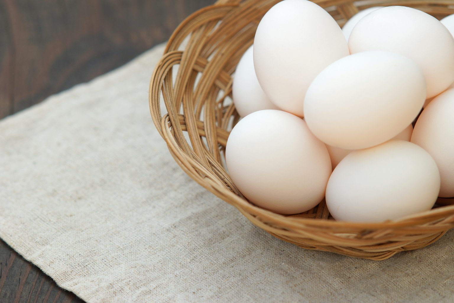 A wicker basket filled with white eggs