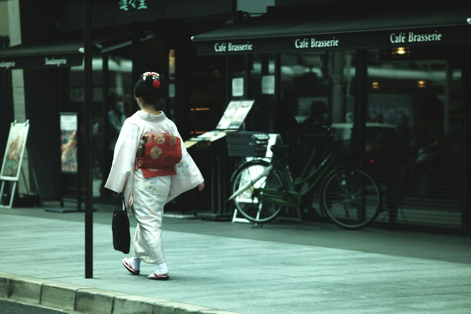 Une femme en kimono marchant devant un café