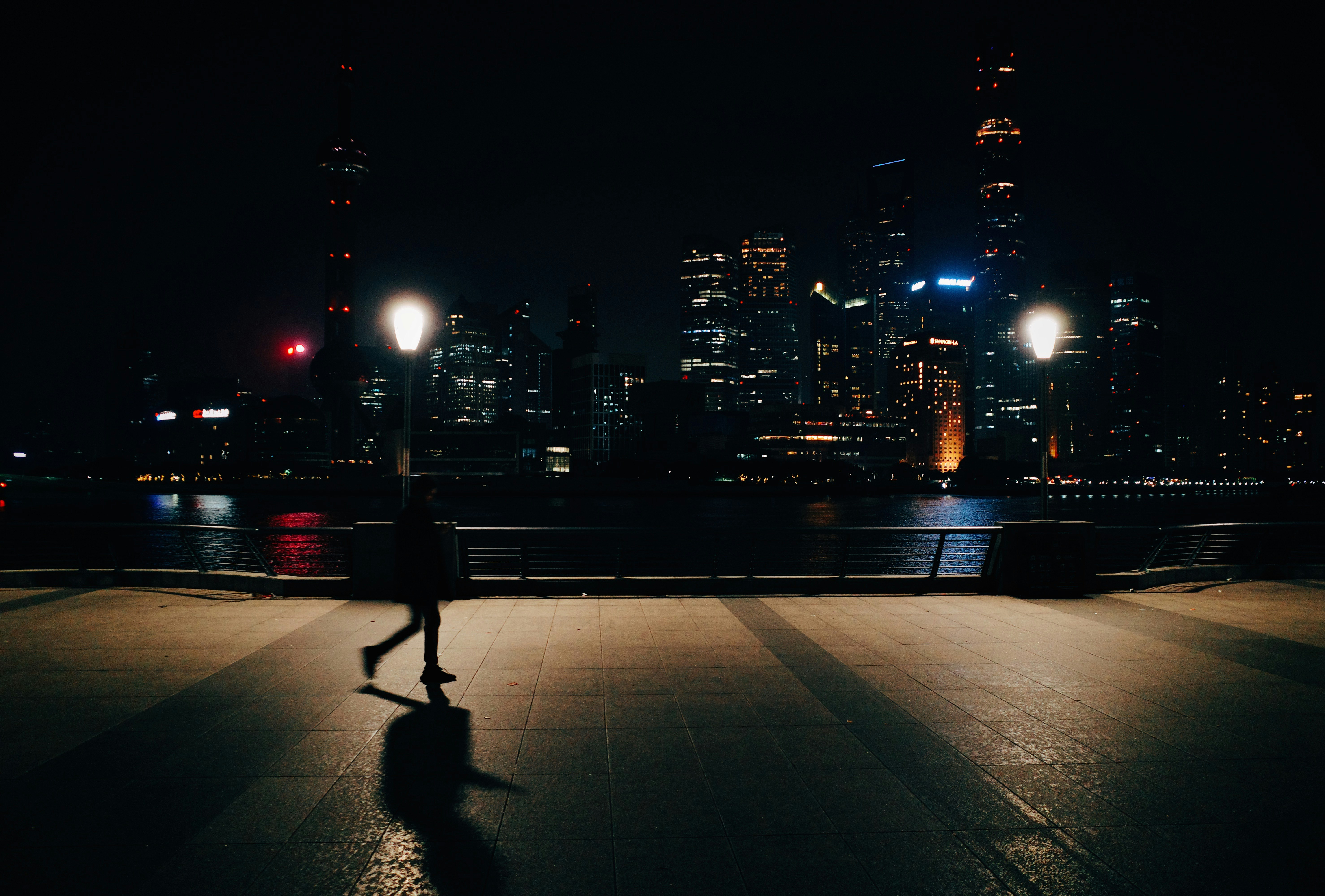 夜の港の遊歩道と遠景の高層ビル群