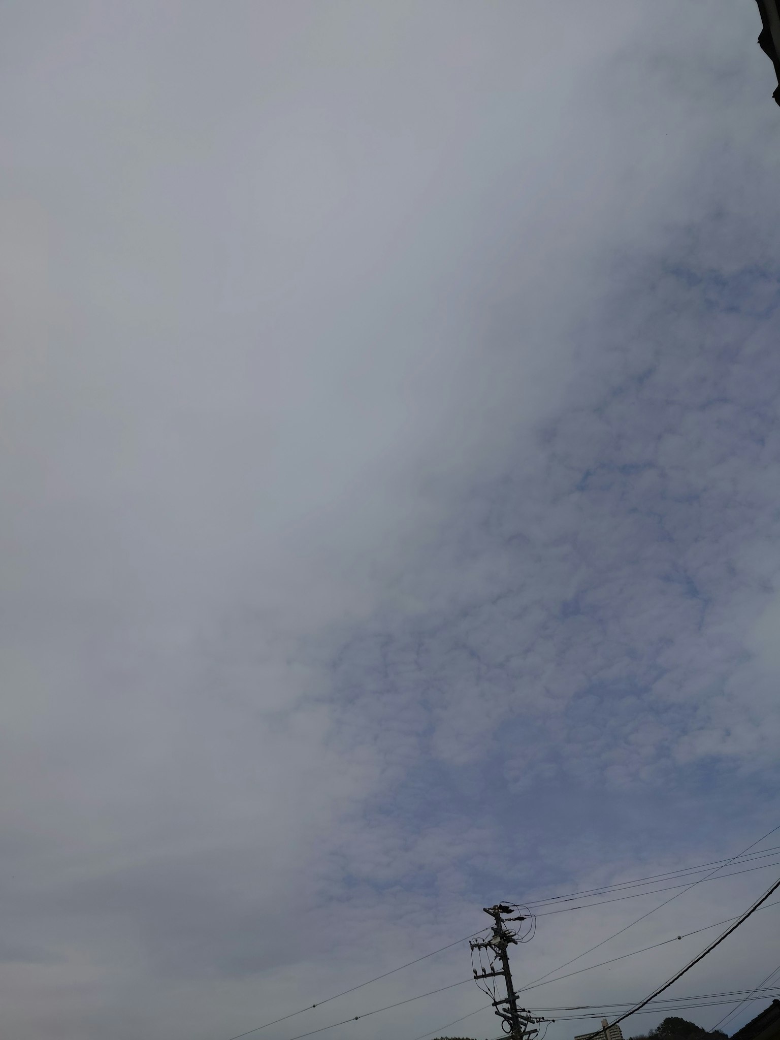 Overcast sky with visible blue areas and a utility pole