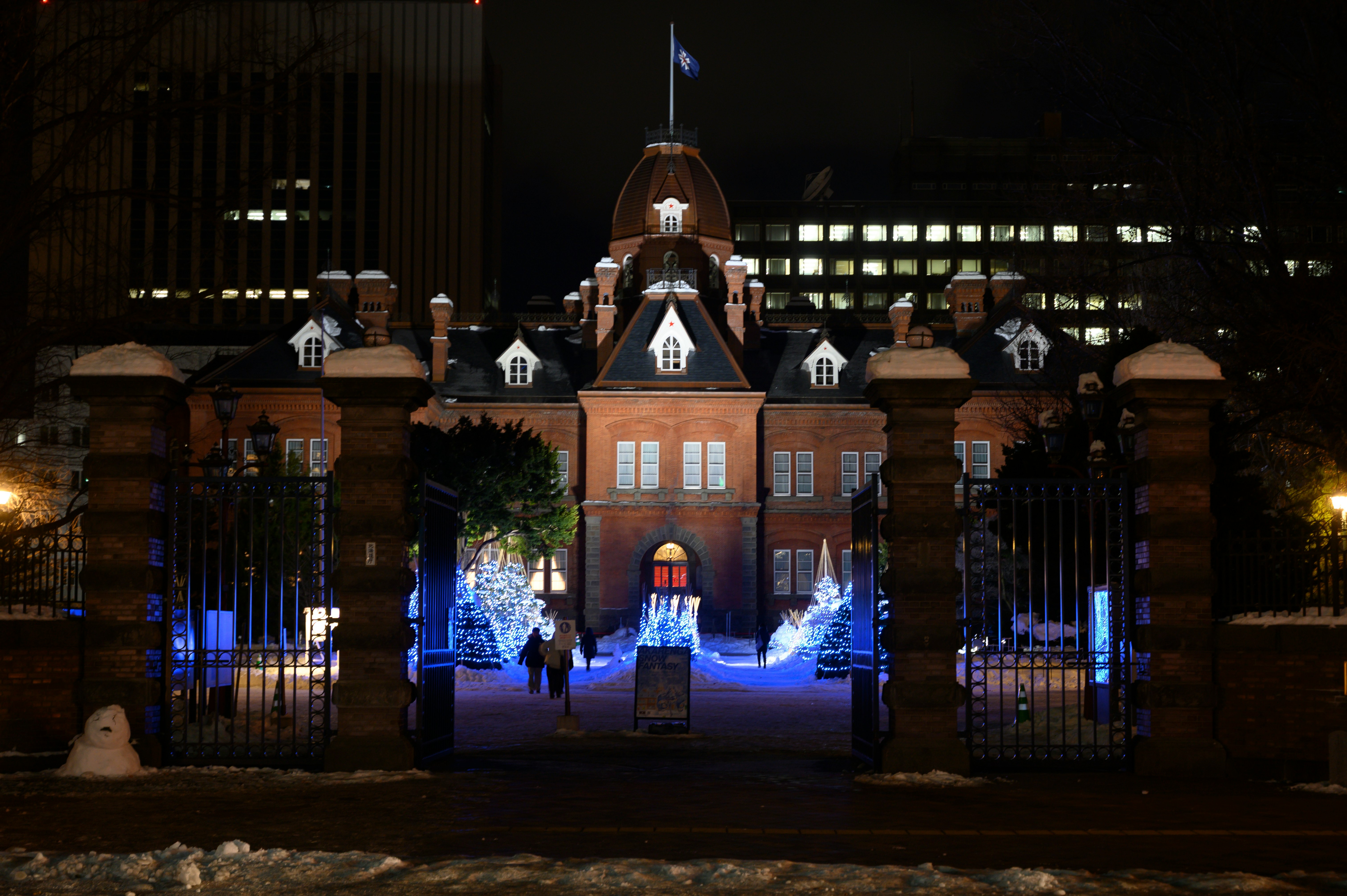 bâtiment en briques illuminé la nuit et allée de cour