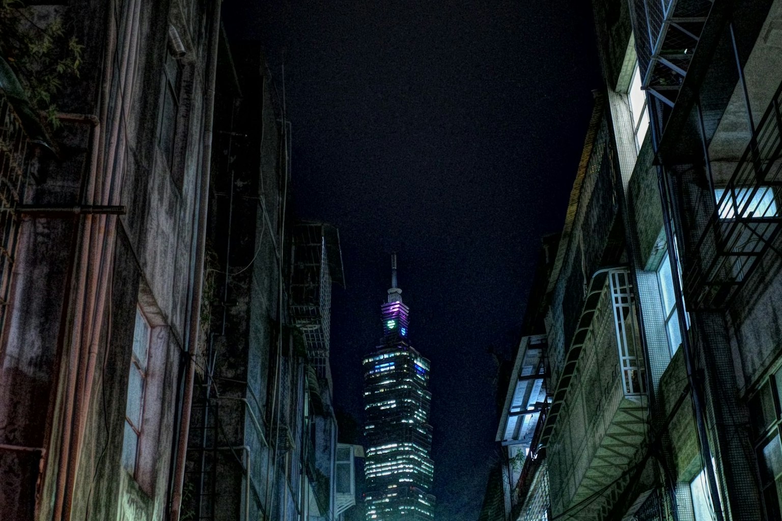 夜の都市の狭い路地から見上げた高層ビルの画像