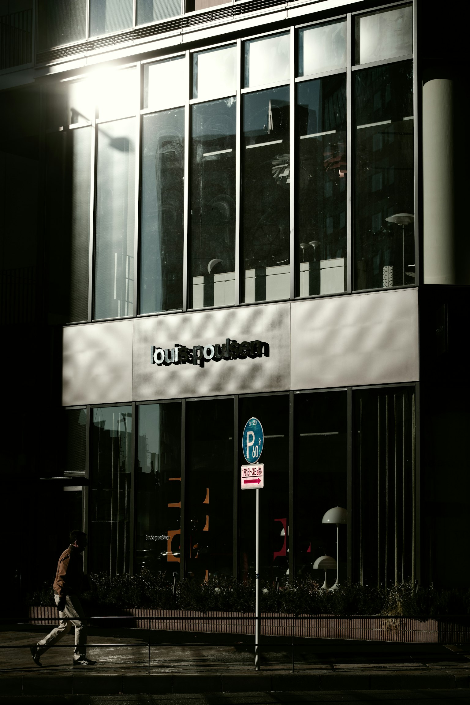 現代建築外觀,玻璃外立面和在陰影街道上行走的人