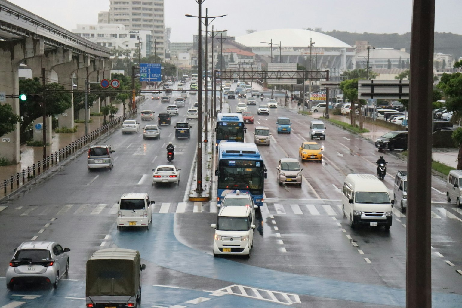 Scena di traffico sotto la pioggia con autobus e auto in un contesto urbano