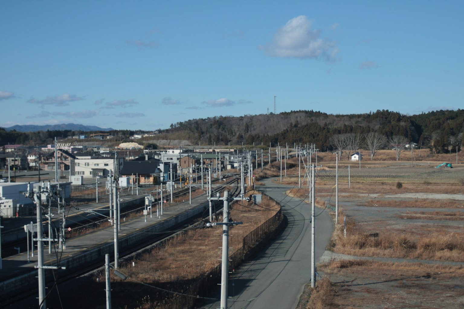 Strada curva e ferrovia in un paesaggio rurale