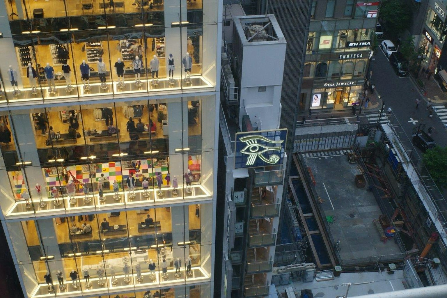 Städtische Ansicht mit einem Hochhaus und beleuchteten Geschäften
