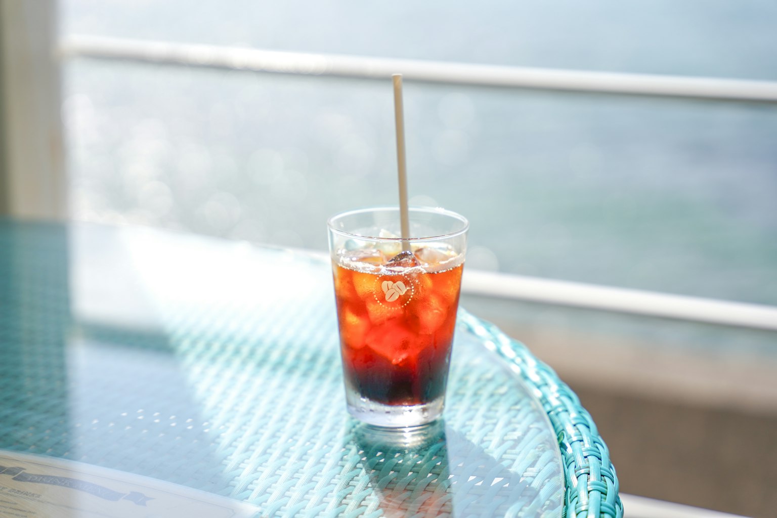 Ein Glas Eistee auf einem Tisch mit blauem Hintergrund