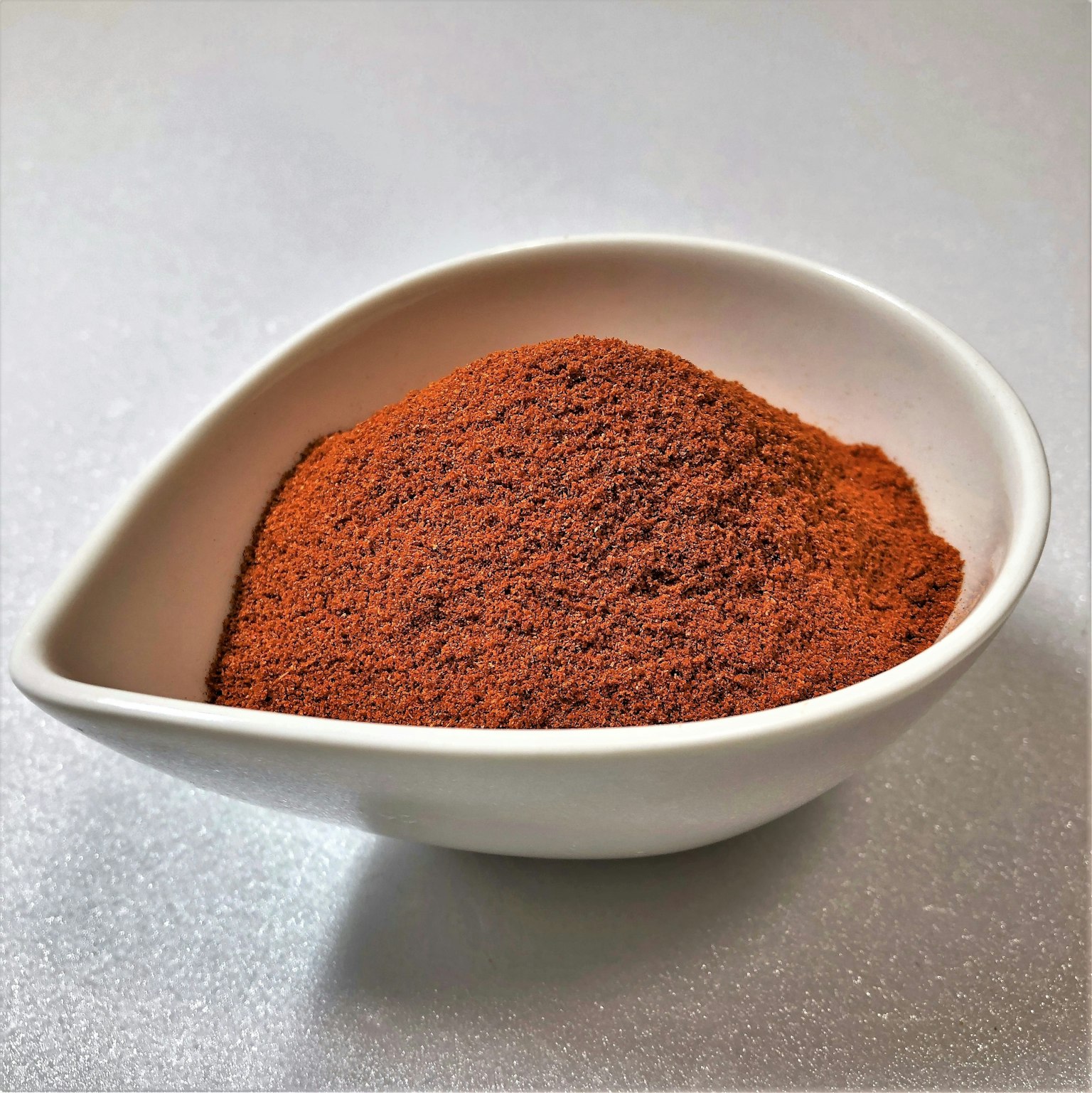 Một đống bột gia vị màu đỏ trong đĩa trắng