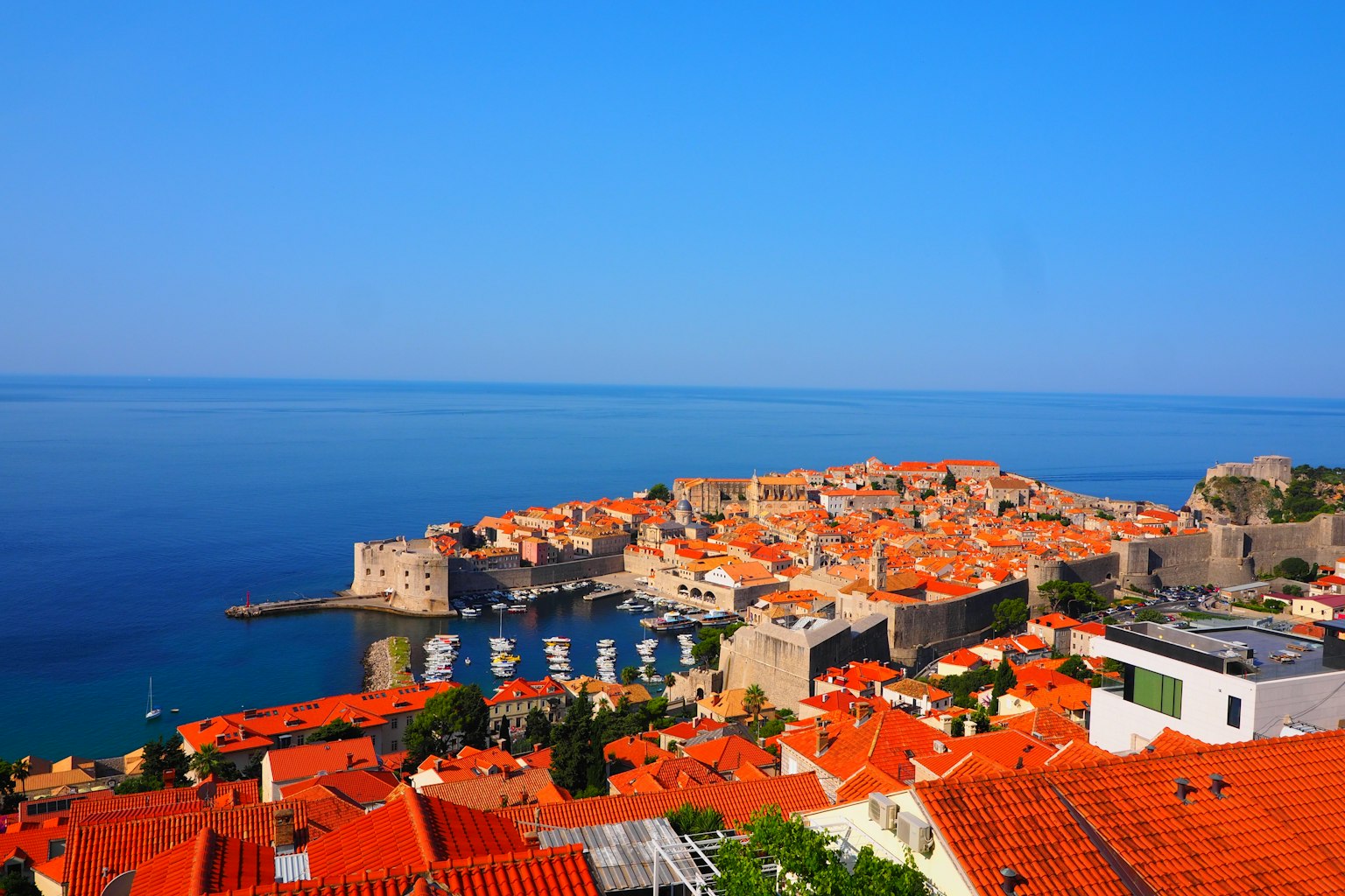 Vista panoramica della costa di Dubrovnik con tetti arancioni sotto un cielo blu