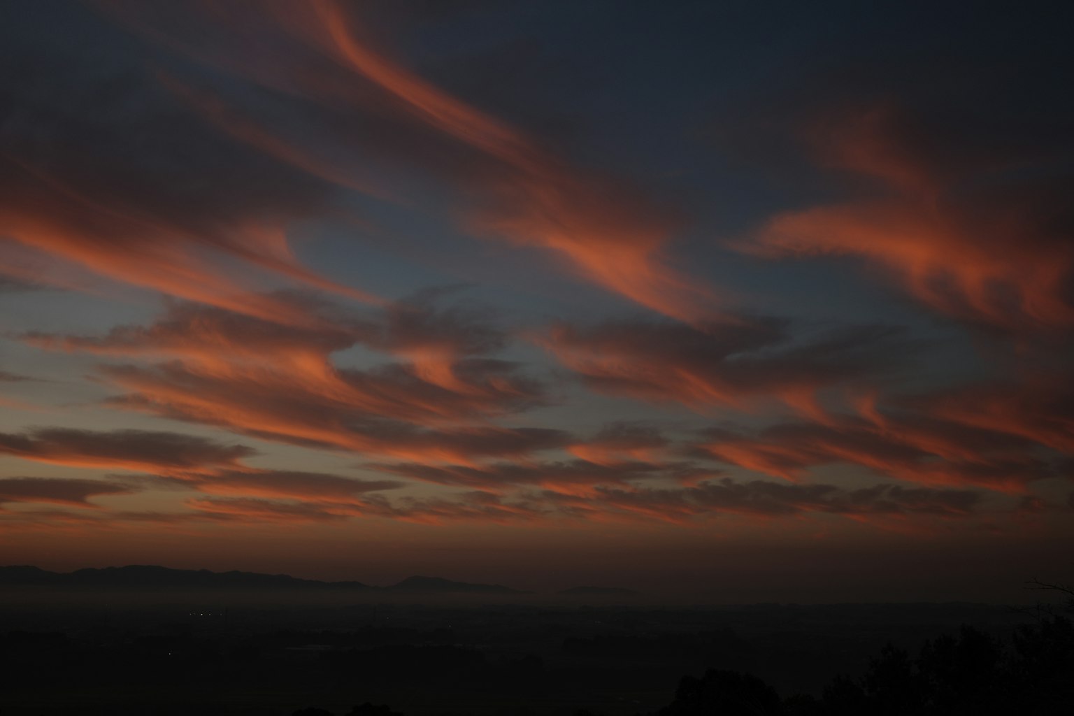夕焼けの空に広がるオレンジ色の雲と青い背景