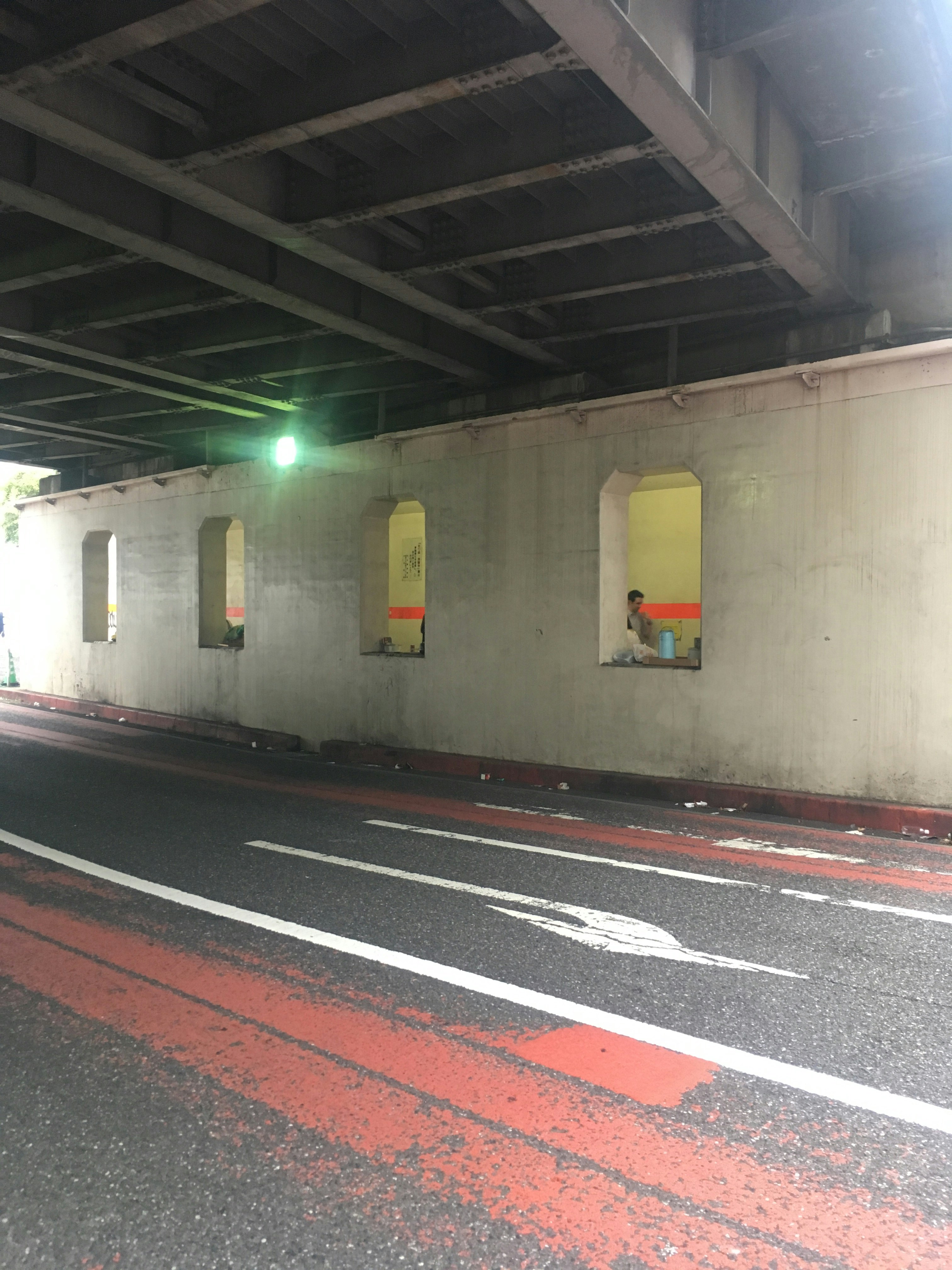 高架下の壁に描かれたカラフルなアートと空の駐車スペース