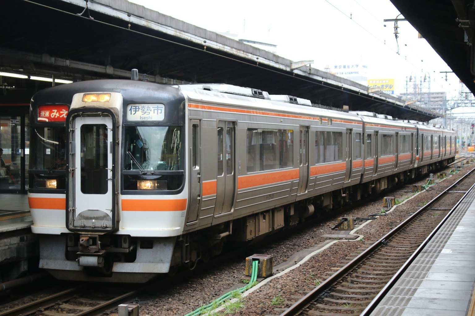 Treno giapponese con strisce arancioni distintive fermo in stazione